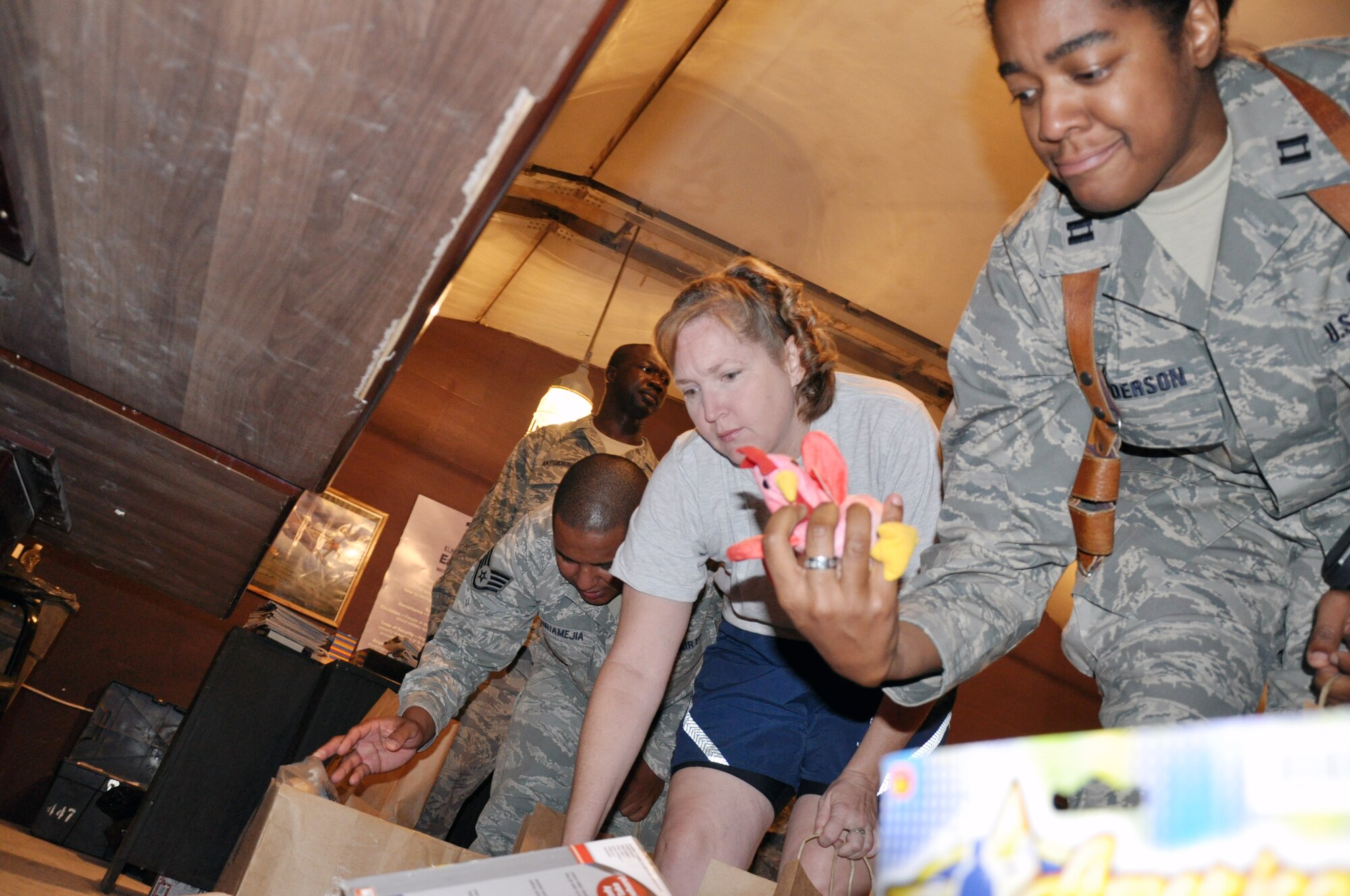 Volunteers move down the line, grabbing items they hope will brighten the day of the children of Iraqi soldiers as part of the Good Neighbor Program.  This program is an initiative designed to provide care packages for the families of Iraqi soldiers stationed in the area and to build stronger relationships between members of the U.S. and Iraqi militaries.  Originally started by junior enlisted volunteers from Sather Air Base, Baghdad, the GNP volunteer force has spread to all ranks and services throughout the Victory Base Complex and the Baghdad area.  (U.S. Air Force photo by Tech. Sgt. Mike Edwards)