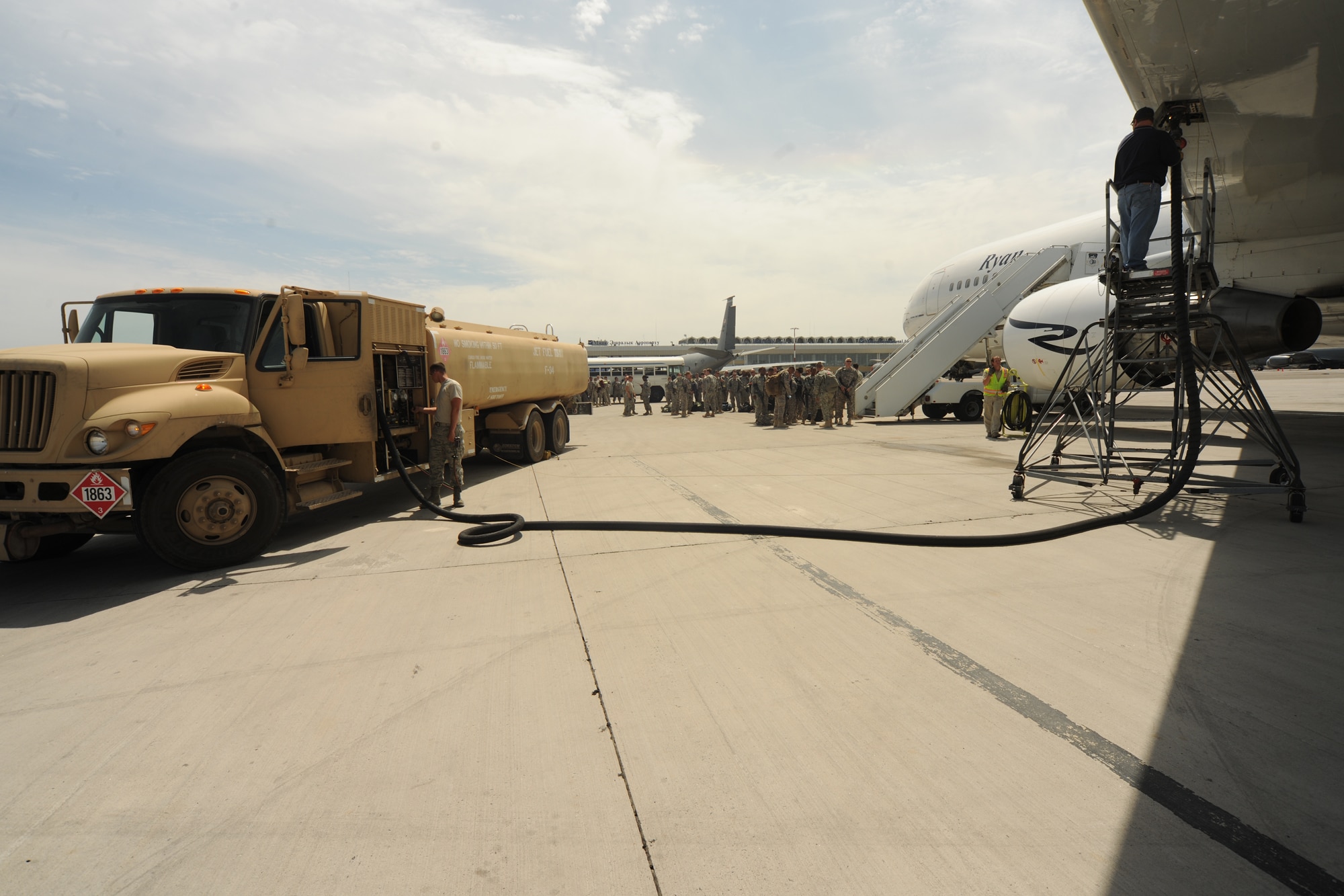 TRANSIT CENTER AT MANAS, Kyrgyzstan - Airman 1st Class Bryan Stevens (left), 376th Logistics Readiness Squadron, pumps fuel Aug. 3 to a Boeing 767 Army soldiers board for Nurnberg, Germany  after returning from a one-year deployment to Kandahar, Afghanistan. The Transit Center?s petroleum, oils and lubricant Airmen are responsible for the Air Force?s largest fuel farm in the world. (U.S. Air Force photo/Staff Sgt. Nathan Bevier)