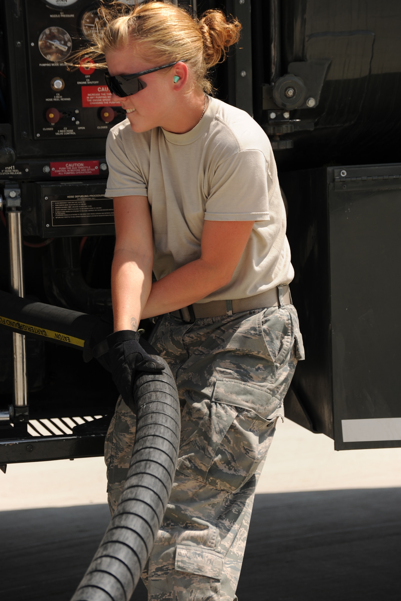 TRANSIT CENTER AT MANAS, Kyrgyzstan - Airman 1st Class Ashley Turnage, 376th Logistics Readiness Squadron fuels distribution operator, winds up a fuel hose after fueling a Boeing 767 before it departs with soldiers returning home Aug. 3. The Transit Center moves 80 percent of the troops going in and out of Afghanistan for Operation Enduring Freedom. (U.S. Air Force photo/Staff Sgt. Nathan Bevier)