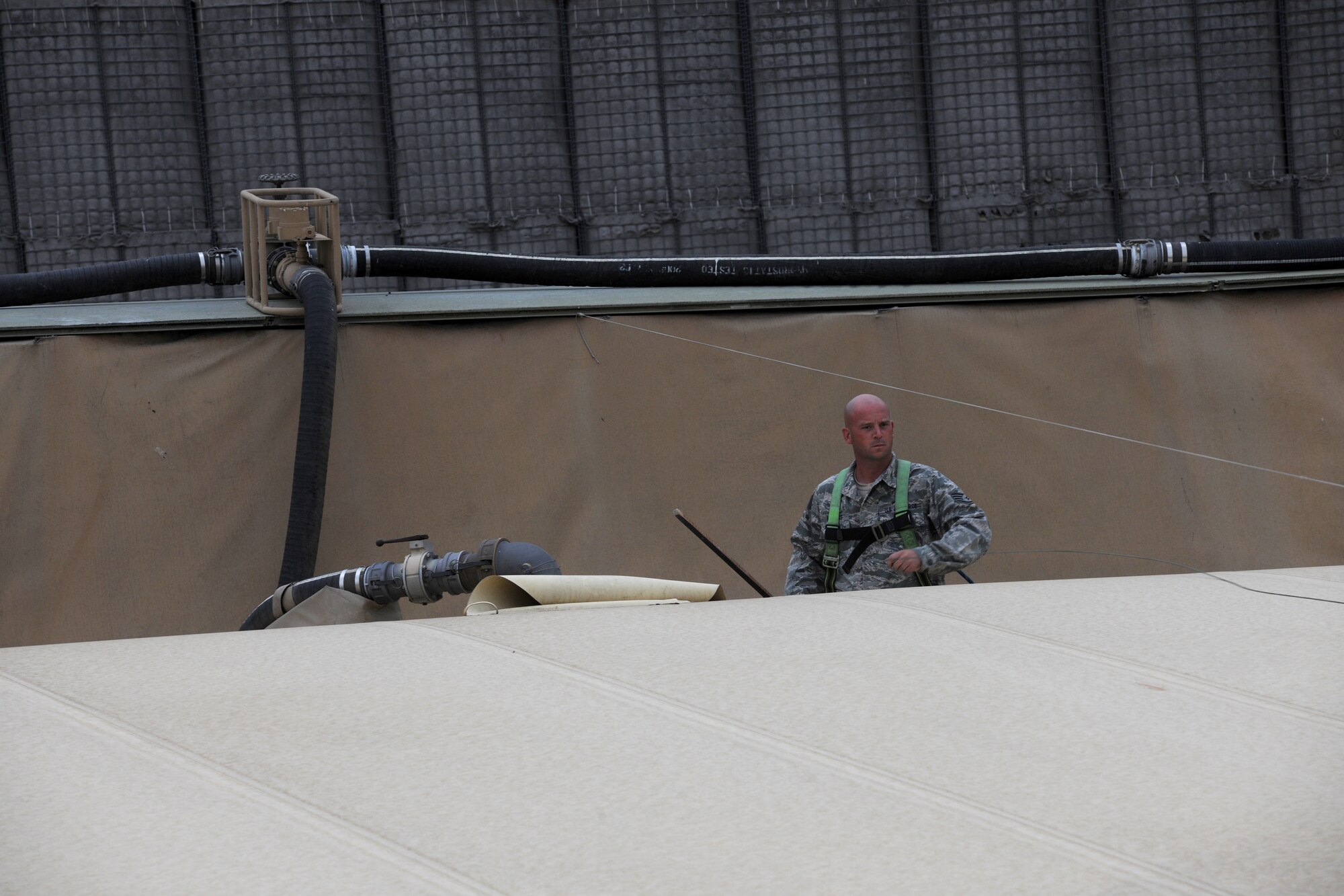 TRANSIT CENTER AT MANAS, Kyrgyzstan - Staff Sgt. Benjamin Lowers, 376th Logistics Readiness Squadron, checks the fuel level of a bladder July 16. Each bladder can hold 200,000 gallons. (U.S. Air Force photo/Staff Sgt. Nathan Bevier)