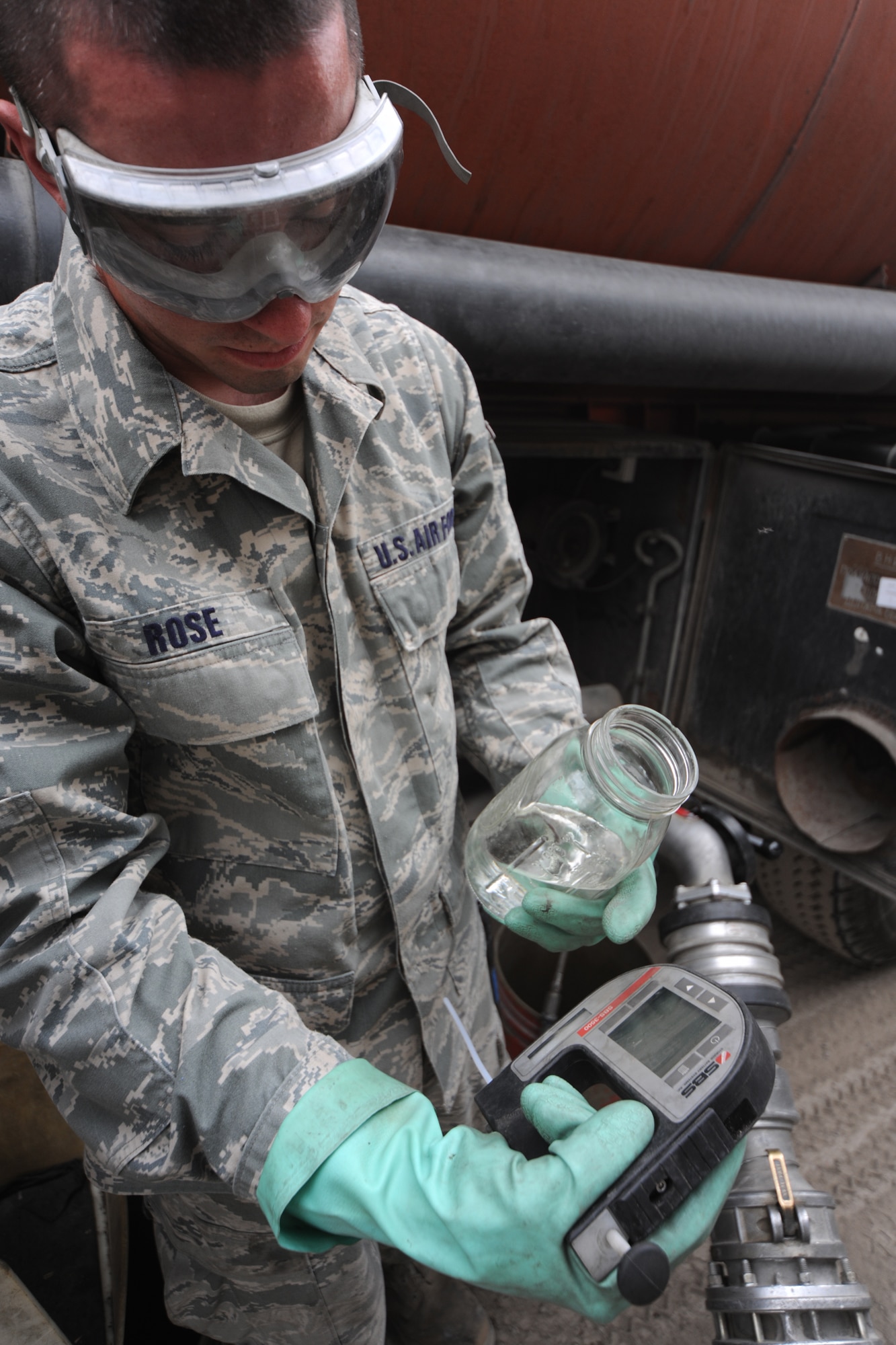 TRANSIT CENTER AT MANAS, Kyrgyzstan - At the header Airman Justin Rose, 376th Logistics Readiness Squadron, takes a sample of fuel and tests it before allowing the fuel to enter into the filtration system July 16. The header is open 18 hours a day and receives between 40-60 trucks that offload about 8,000 gallons each. (U.S. Air Force photo/Staff Sgt. Nathan Bevier)