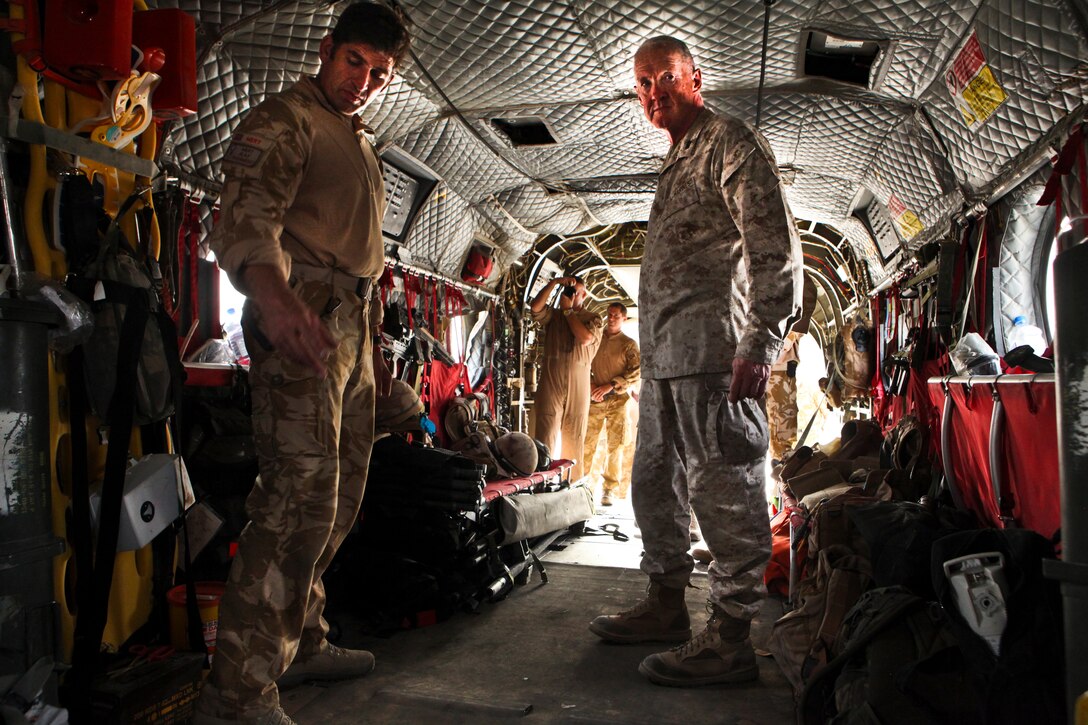Maj. Gen. Richard Mills, commanding general of Regional Command Southwest, right, listens as Flight Lieutenant Andy Smith, a member of the Medical Emergency Response Team with the U.K.'s Joint Helicopter Force (Afghanistan), explains the MERT's capabilities equipment during the general's tour of JHF(A)'s flight line here August 7.  Mills toured the area to thank aircrew, maintainers and pilots for their hard work.  JHF(A), along with U.S. squadrons under the 3rd Marine Aircraft Wing (Forward), provide everything from assault support to cargo delivery for Afghan National Security and NATO forces in Helmand province.