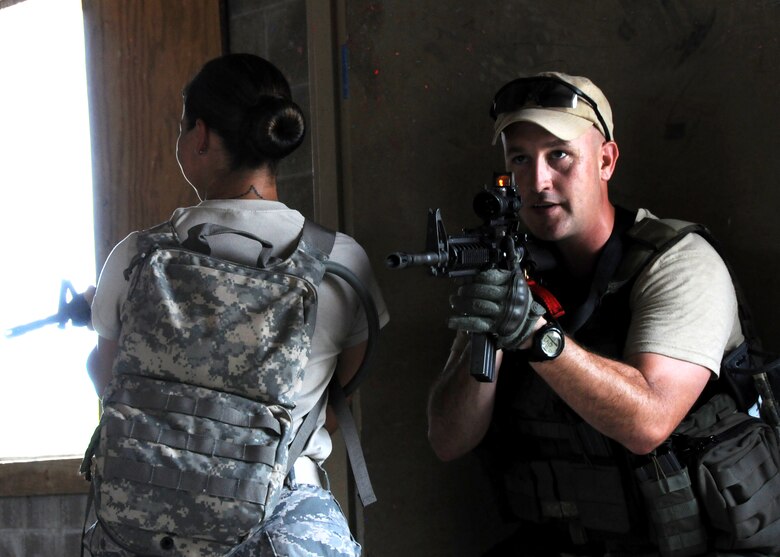 Master Sgt. William Stapp and Tech. Sgt. Candice Wahowski, 919th Security Forces Squadron, guard the door during room-clearing training at Eglin Air Force Base Fla.  SFS teams practiced entry and clearing tactics and procedures with varying targets, objectives and ammunition Aug. 7.  Blanks and simulated munitions were used to create a more realistic scenario for the Reservists from Duke Field.  (U.S. Air Force photo/Tech. Sgt. Samuel King Jr.)