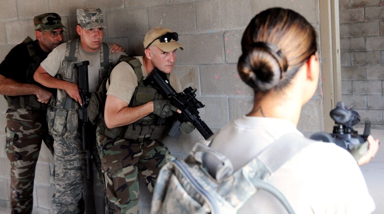 Members of a fire team wait for clearance to proceed from Tech. Sgt. Candice Wahowski, 919th Security Forces Squadron, during room clearing training at Eglin Air Force Base Fla.  SFS teams practiced entry and clearing tactics and procedures with varying targets, objectives and ammunition Aug. 7.  Blanks and simulated munitions were used to create a more realistic scenario for the Reservists from Duke Field.  (U.S. Air Force photo/Samuel King Jr.)