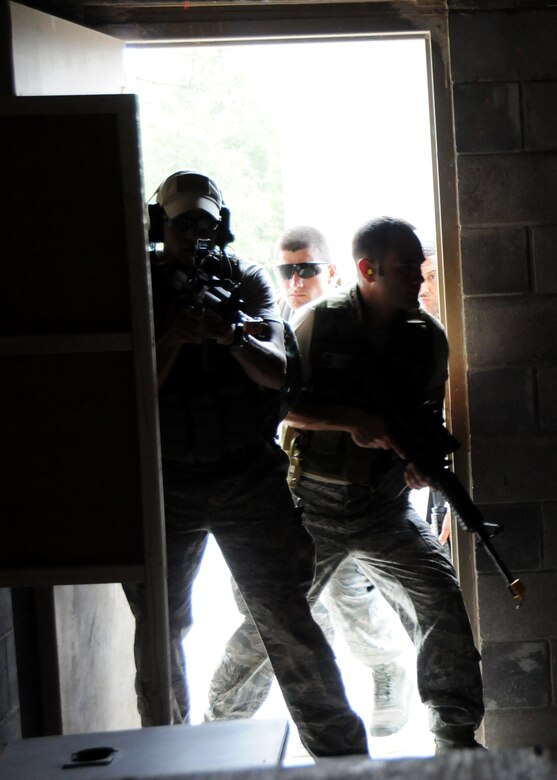 A 919th Security Forces Squadron fire team bursts through the door during room clearing training at Eglin Air Force Base Fla.  SFS teams practiced entry and clearing tactics and procedures with varying targets, objectives and ammunition Aug. 7.  Blanks and simulated munitions were used to create a more realistic scenario for the Reservists from Duke Field.  (U.S. Air Force photo/Tech. Sgt. Samuel King Jr.)