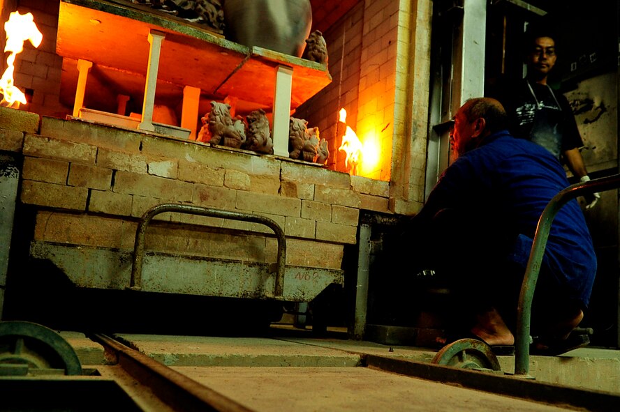 Mr. Hideo Miyagi, a famous Okinawan Potter, lights his massive kiln to begin the final process of setting his nationally renowned pottery at his shop in the Chibana district of Okinawa July 15, 2010. (U.S. Air Force photo/Senior Airman Amanda Grabiec)

