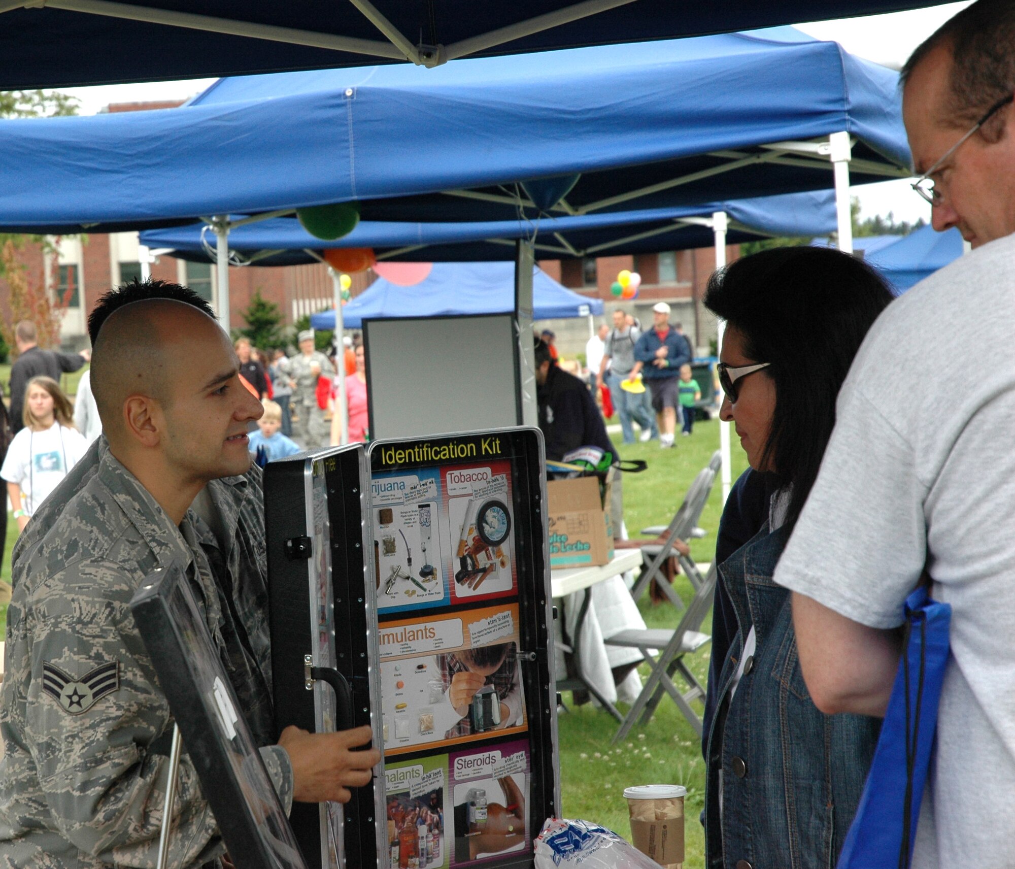JOINT BASE LEWIS-MCCHORD, Wash.- Senior Airman Aaron Soto Valencia, medical technician with the 446th Aerospace Medicine Squadron here, explains how recreational drugs are disguised to look like candy, during the 446th Airlift Wing's annual Family Day at Heritage Hill Aug. 7. Other representatives at  information booths included USAA, Phoenix University, the Airmen and Family Readiness Center and the 446th Safety Office. (U.S. Air Fore photo/Staff Sgt. Nicole Celestine)