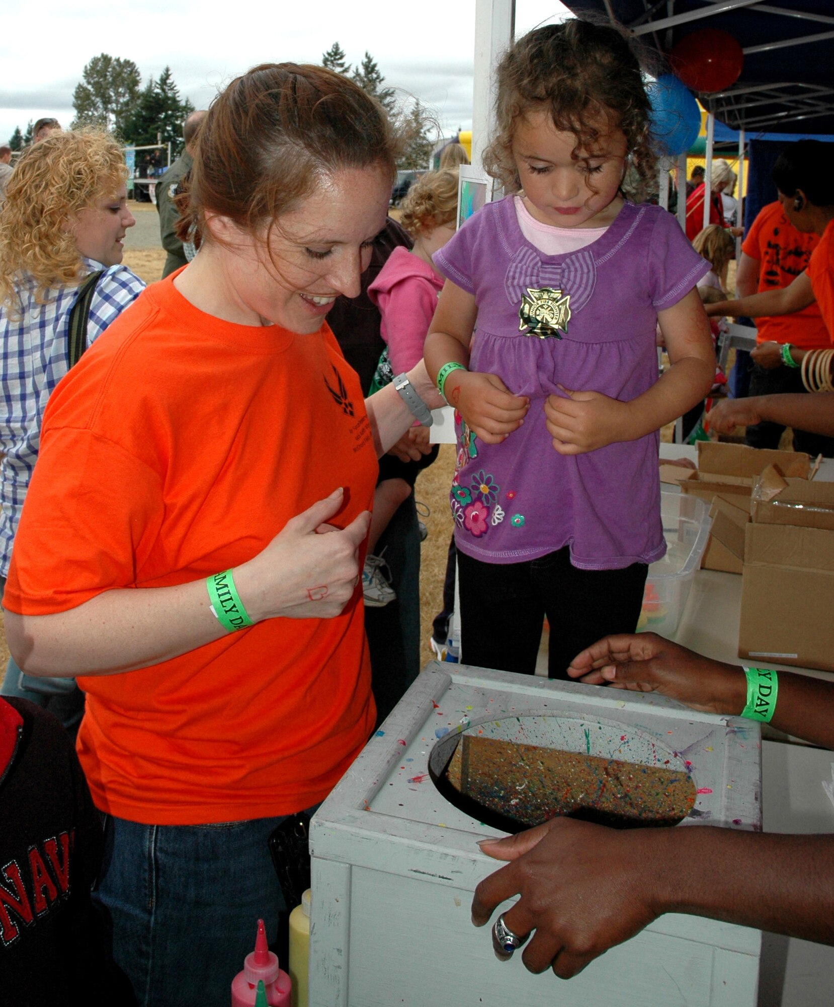 JOINT BASE LEWIS-MCCHORD, Wash.- Senior Master Sgt. Cindy Thomas, 446th Airlift Wing staff client support technician, and her 2-year-old daugther Cassie, look on as their spin art develops. This was one of the activities at the 446th Airlift Wing's annual Family Day held at Heritage Hill here, Aug. 7. (U.S. Air Force photo/Staff. Sgt. Nicole Celestine). 