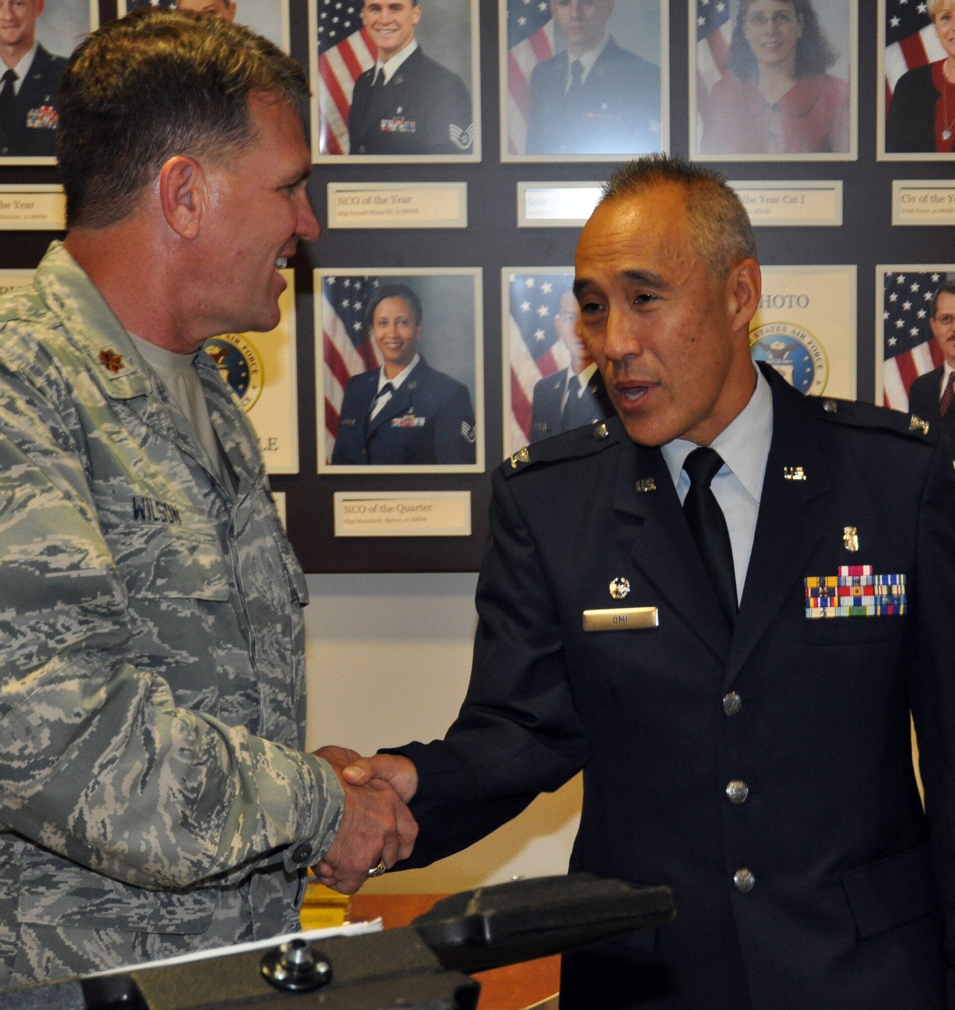 Maj. Tim Wilson, 302nd Airlift Wing chaplain, left, congratulates Col. Sheldon Omi following a change of command ceremony Aug. 7 at Peterson Air Force Base, Colo. Colonel Omi is the new commander of the 302nd Aeromedical Staging Squadron. (U.S. Air Force photo/Tech. Sgt. Daniel Butterfield)