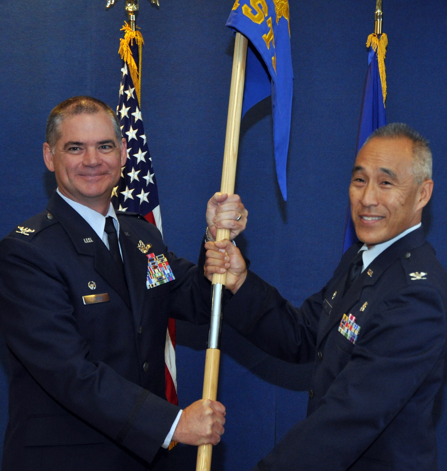 Col. Jack H. Pittman Jr., left, commander, 302nd Airlift Wing, hands the 302nd Aeromedical Staging Squadron guidon to Col. Sheldon Omi during Omi's assumption of command ceremony Aug. 7 at Peterson Air Force Base, Colo.  (U.S. Air Force photo/Tech. Sgt. Daniel Butterfield)