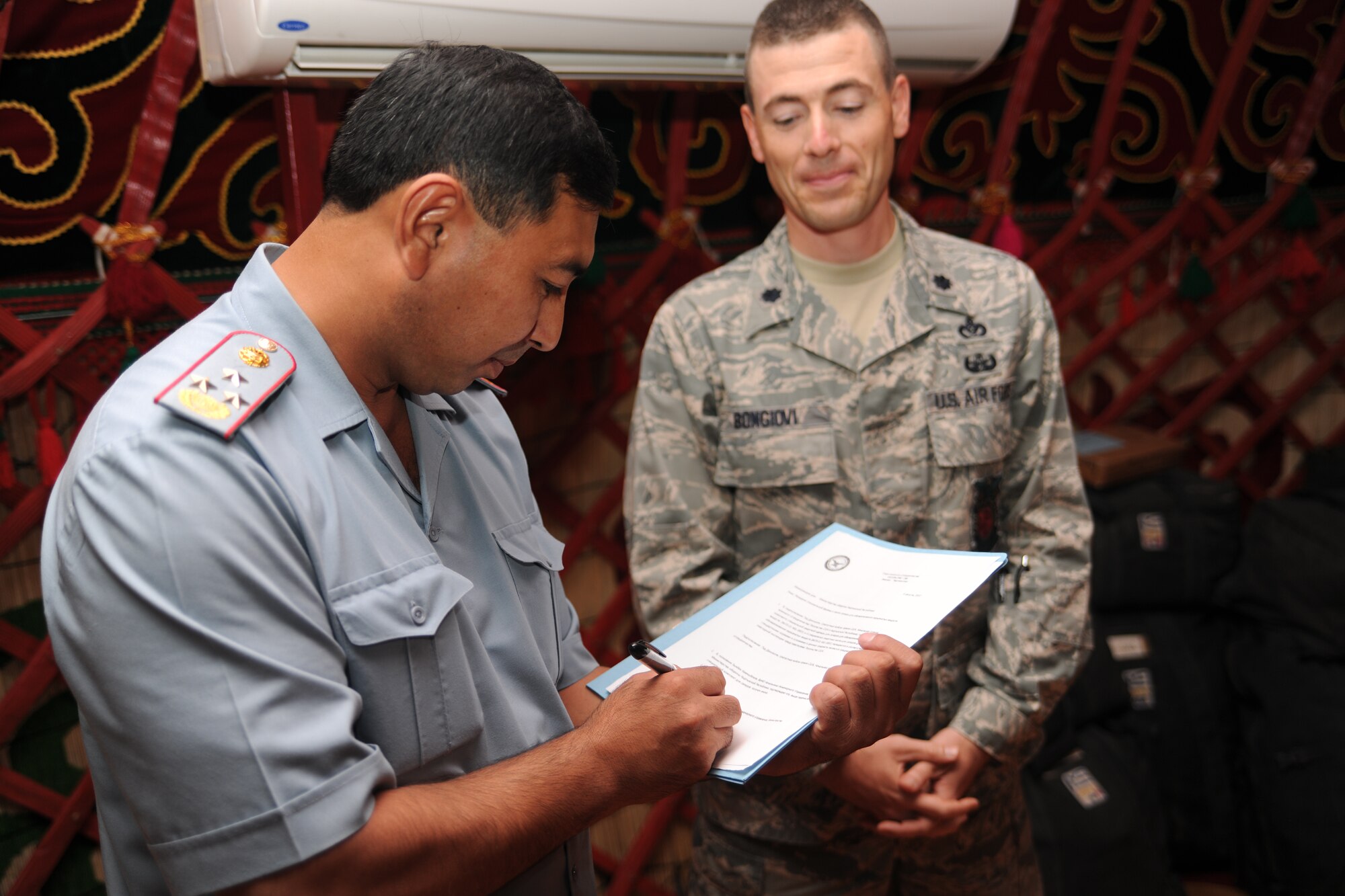 TRANSIT CENTER AT MANAS, Kyrgyzstan ? Colonel Ziabek Beishebekovich Kamchibekov signs to accept four bomb suits on behalf of the U.S. Air Force during a graduation ceremony Aug. 6 for 14 of his soldiers who completed a five-day course by EOD. (U.S. Air Force Photo/Staff Sgt. Nathan Bevier)