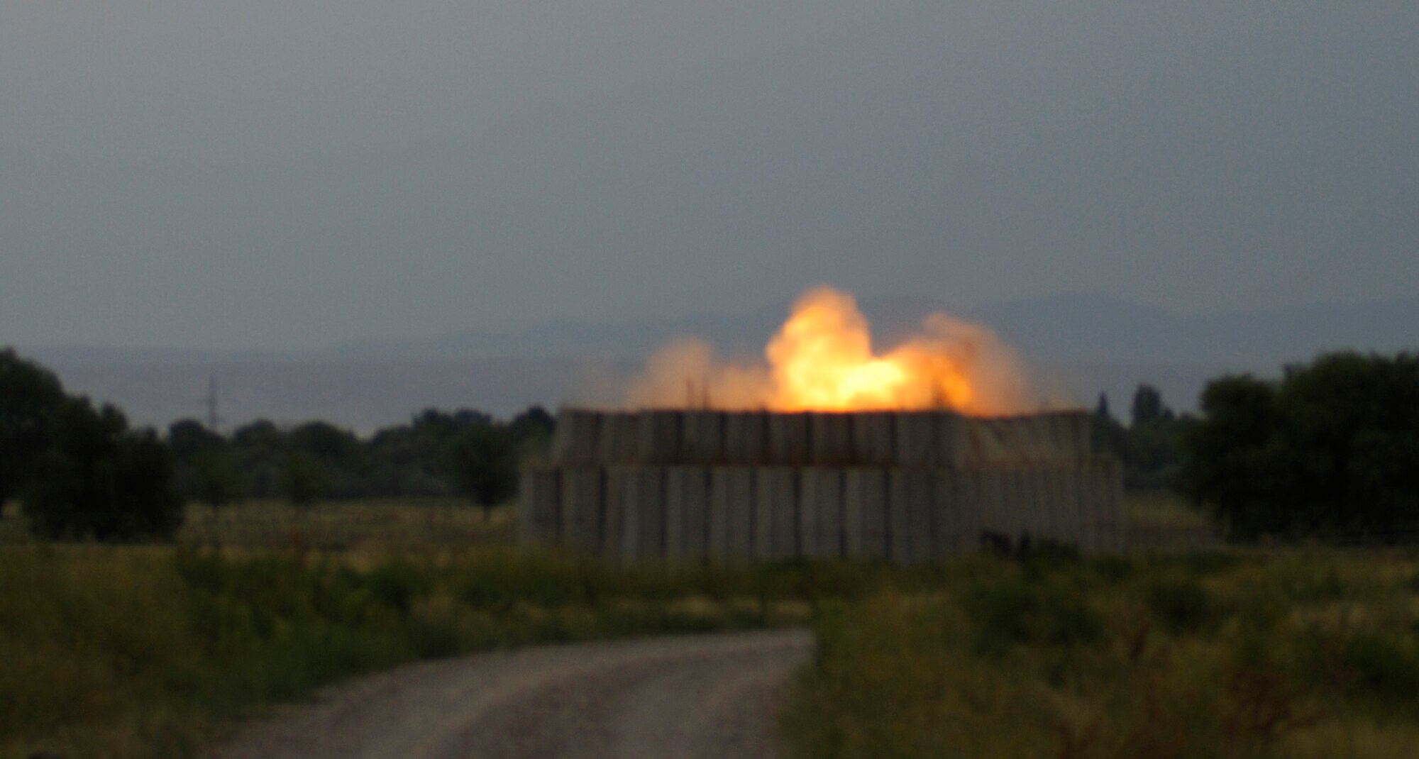 TRANSIT CENTER AT MANAS, Kyrgyzstan ? From a safe distance, U.S. and Kyrgyzstan EOD technicians watch the final blast of the day to clean up leftover explosives. This was one of five detonations done on the range Aug. 5. The five-day course of Kyrgyz EOD technicians learning from their U.S. counterparts culminated with the Air Force giving their host nation?s military four bomb suits. (U.S. Air Force Photo/Tech. Sgt. Jennifer Buzanowski)