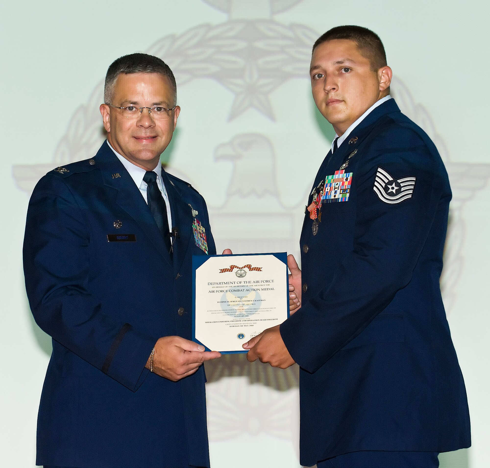 Col. Randal L. Bright, commander, 512th Airlift Wing, Dover Air Force Base, Del., presents Tech. Sgt. Stephen J. Kaufman, of the 512th Civil Engineer Squadron, Aug. 7, 2010, with the Air Force Combat Action Medal for having been under direct and hostile fire in connection with military operations while supporting Operations Iraqi and Enduring Freedom September 2009 to March 2010. (U.S. Air Force photo/Roland Balik)