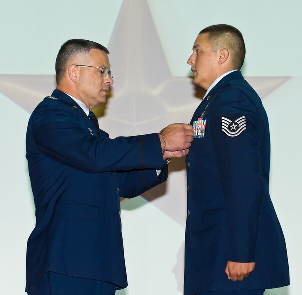 Col. Randal L. Bright, commander, 512th Airlift Wing, Dover Air Force Base, Del., presents Tech. Sgt. Stephen J. Kaufman, 512th Civil Engineer Squadron, with the Bronze Star during commander's call, Aug. 7, 2010. Sergeant Kaufman distinguished as an explosive ordinance disposal team leader while assigned to Combined Joint Task Force Paladin, Kandahar Airfield, Afghanistan from Sep. 30, 2009, to March 31, 2010. During this period, he  contributed to the destruction of 54,000 pounds of munitions items, 108 unexploded ordinance items, 71 named operations and the clearance of 6,871 miles of treacherous roadway. (U.S. Air Force photo/Roland Balik)