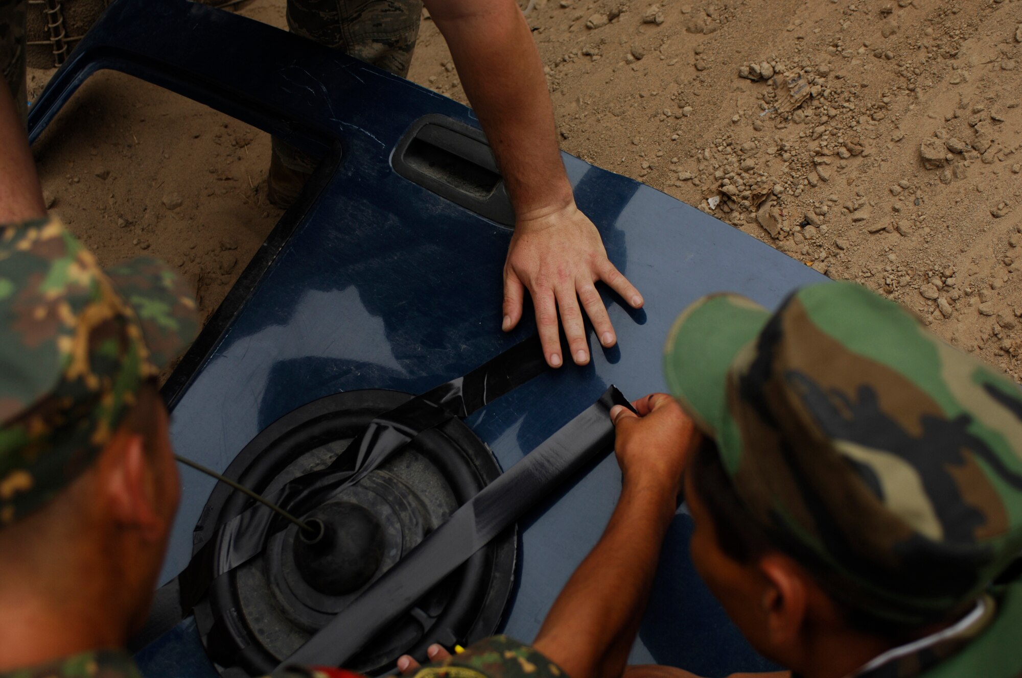 TRANSIT CENTER AT MANAS, Kyrgyzstan ? Krygyz Army soldiers tape explosives to a truck door Aug. 5 at the EOD range during part of a five-day training course given by EOD technicians of the 376th Expeditionary Civil Engineer Squadron. (U.S. Air Force Photo/Tech. Sgt. Jennifer Buzanowski)