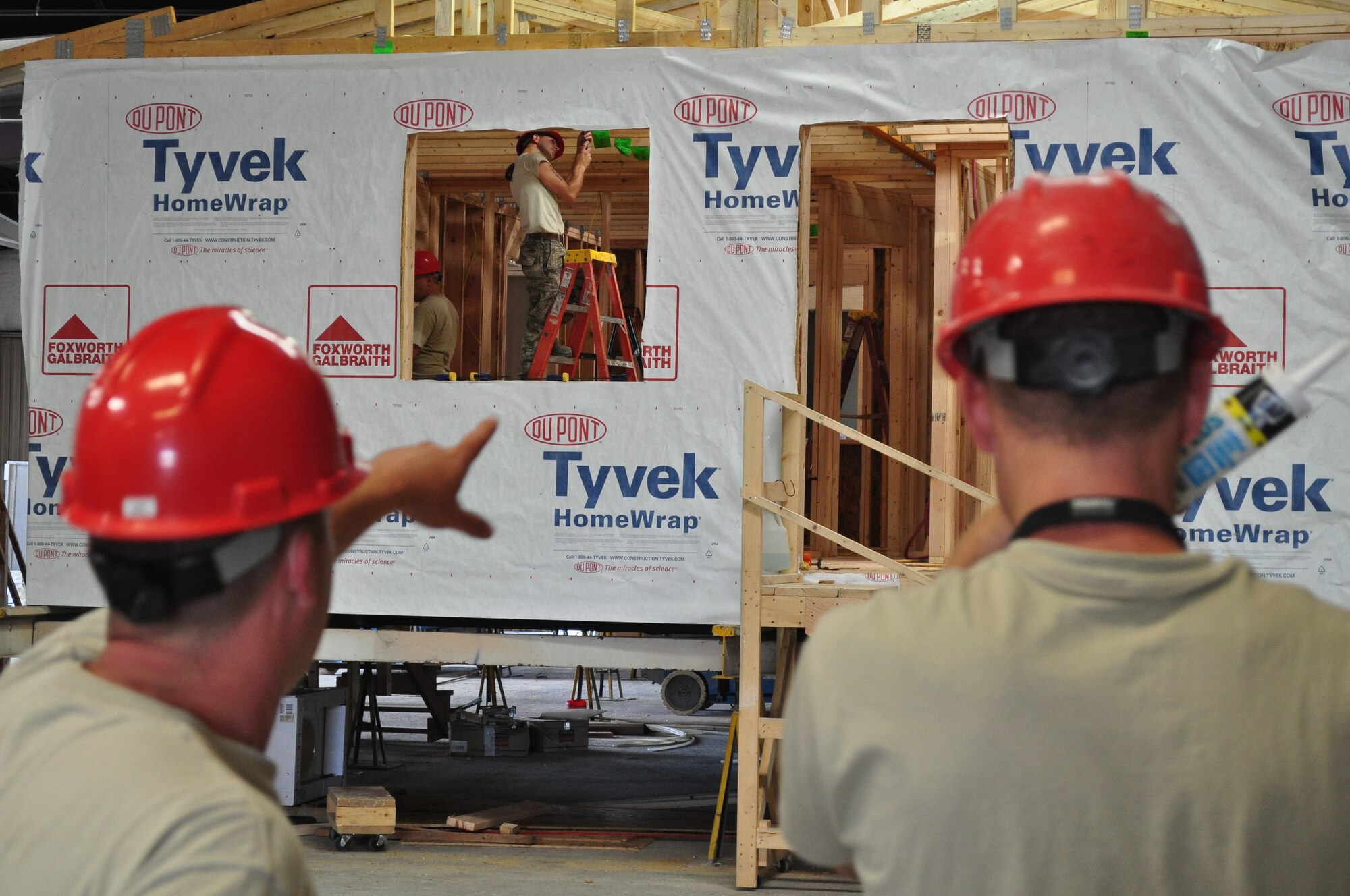 560th Red Horse Squadron members from Charleston AFB, SC talk about construction of a house. They are in Gallup, NM building homes for needy Navajo Indian families. (U.S. Air Force photo/Staff Sgt. Scott Mathews)