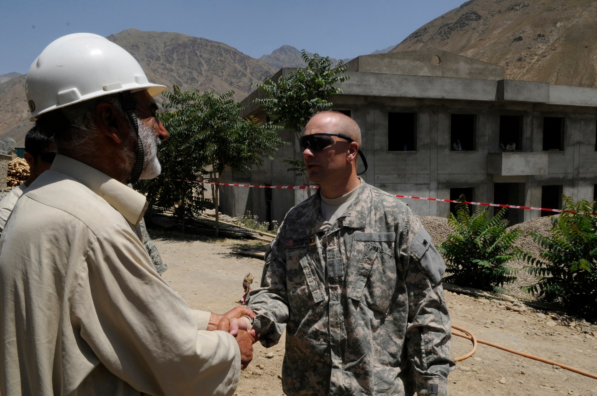 U.S. Army Major Keith Clipp, U.S. Army Corps of Engineers Bagram, resident officer in charge, and Orleans Ill. native, meets with the project engineer while touring the construction site.  During the visit he provided the engineer on site suggestions along with answering questions from the project engineer, Khenj District, Panjshir Province.  (Photo by U.S. Air Force Tech. Sgt. Sean M. White, Provincial Reconstruction Team Panjshir) 