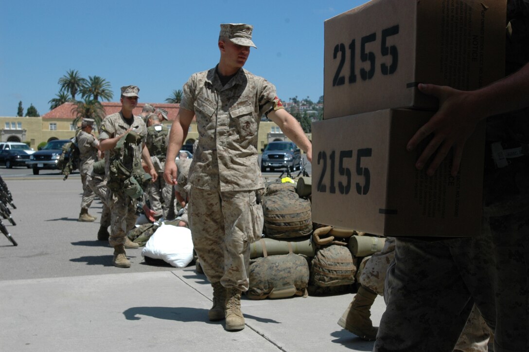 Lance Cpl. Cody Andrew Katz, Platoon 2155, Company G, directs his squad leaders on where to stage the water and Meals, Ready-to-Eat, that they would need for the Crucible. Their gear was staged behind the Shepard's Field Parade Deck here, Aug 8.