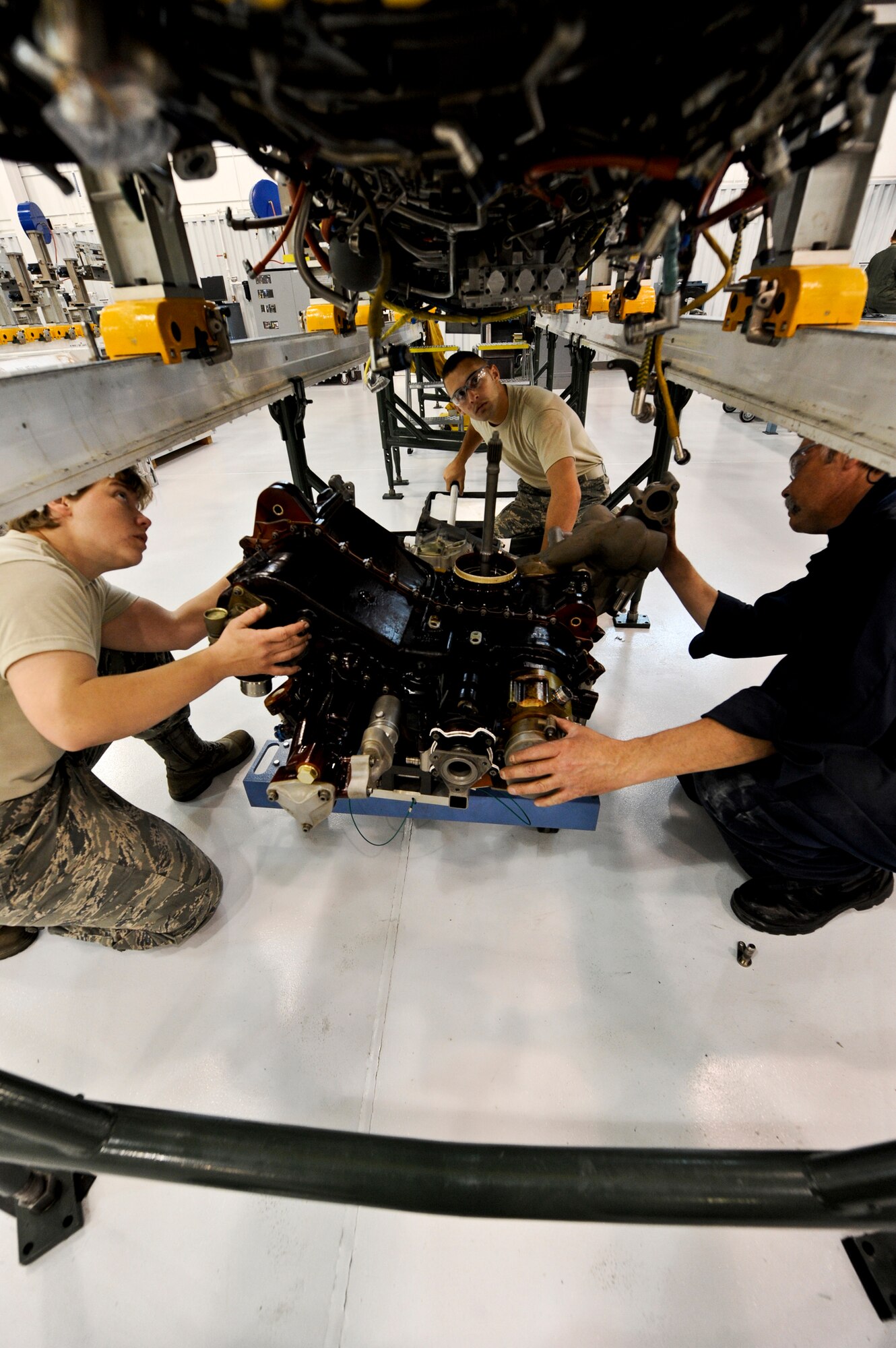 JOINT BASE ELMENDORF-RICHARDSON, Alaska – From left to right, Tech Sgt. Candice Schouten, Airman 1st Class Justin Bleich and Randy Grueneberg, all of the 3rd Component Maintenance Squadron Propulsion Flight, install the gearbox on an F-22 Raptor F119-PW-100 engine Aug. 6. The 3rd CMS was recently named the recipients of the 2010 Secretary of Defense Field-Level Maintenance Award, small category. (Air Force photo by Airman 1st Class Christopher Gross)