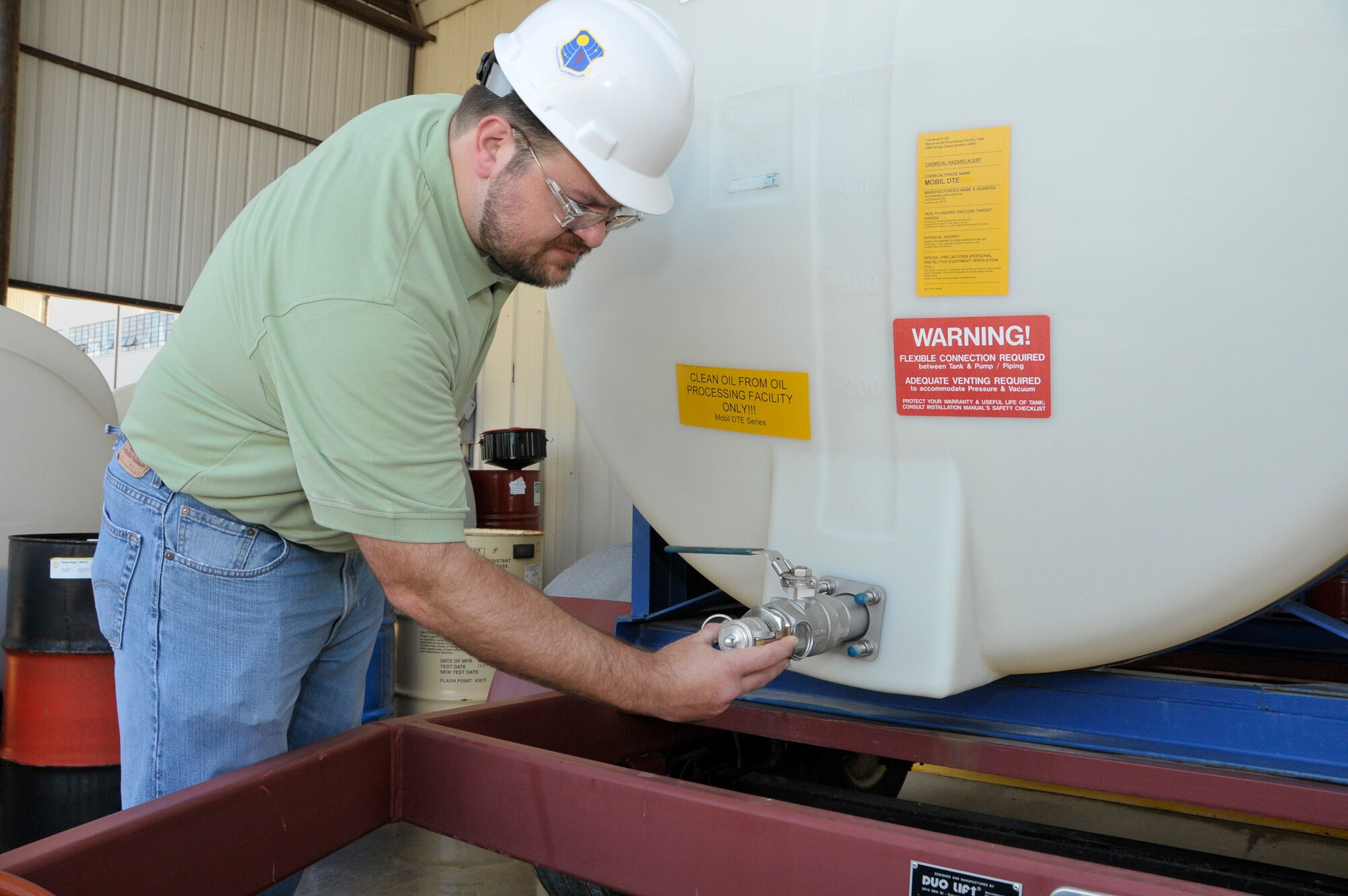 Casey Schewe, ATA Conditioned-Based Maintenance engineer, inspects the condition of a fitting on a clean oil tank at the Oil Processing Facility. Dedicated 1,000-gallon clean-oil tanks are used to transport larger quantities of oil for major maintenance actions or situations requiring increased capacity.  (Photo by Rick Goodfriend)