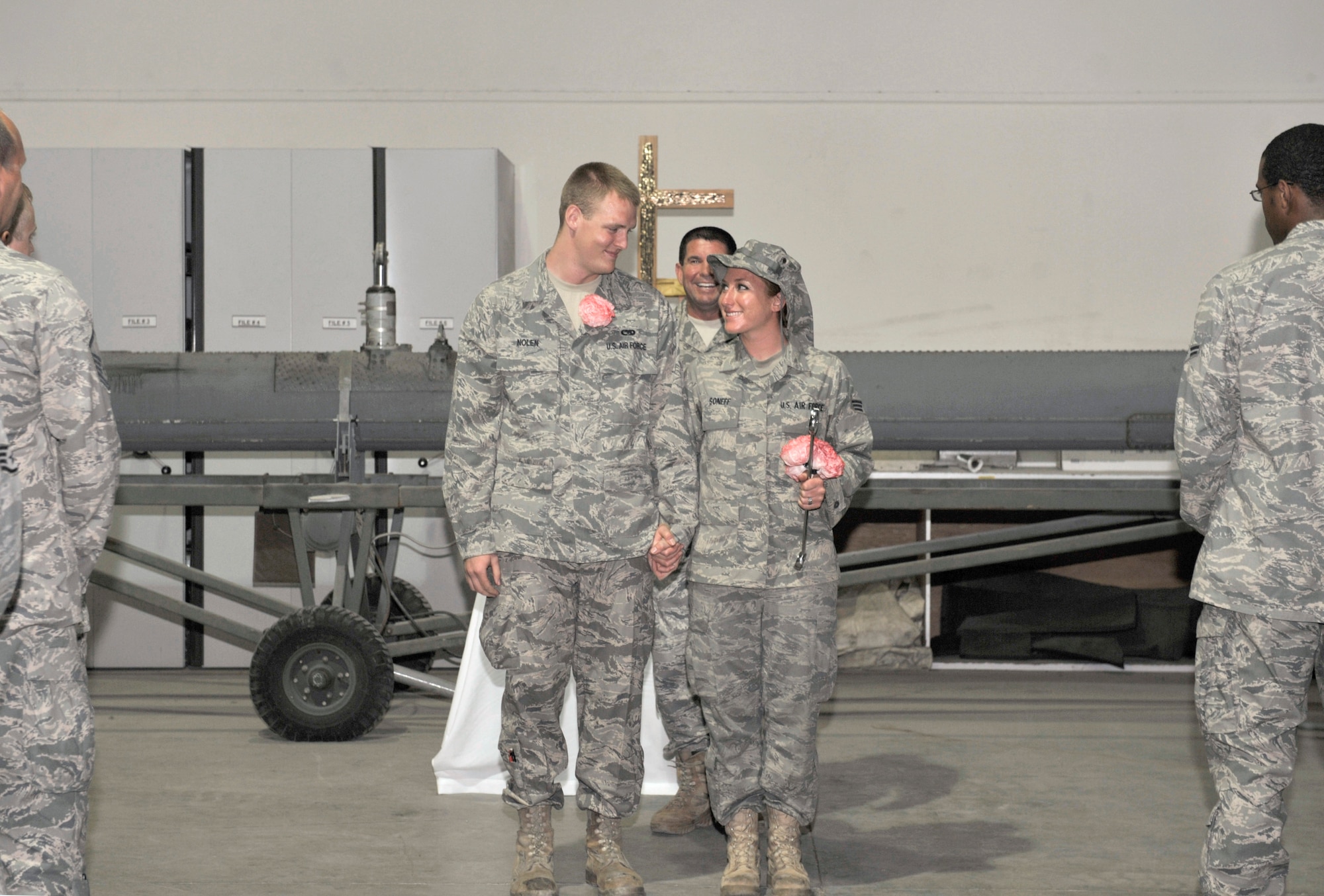 Senior Airman Donald Nolen and Senior Airman Sheri Nolen walk down the aisle as husband and wife after their wedding ceremony Aug 4, 2010, at an air base in Southwest Asia. The Nolens are members of the 380th Expeditionary Aircraft Maintenance Squadron. They were married by proxy on July 12, 2010, through the state of Montana. (U.S. Air Force photo/Tech. Sgt April Wickes) 