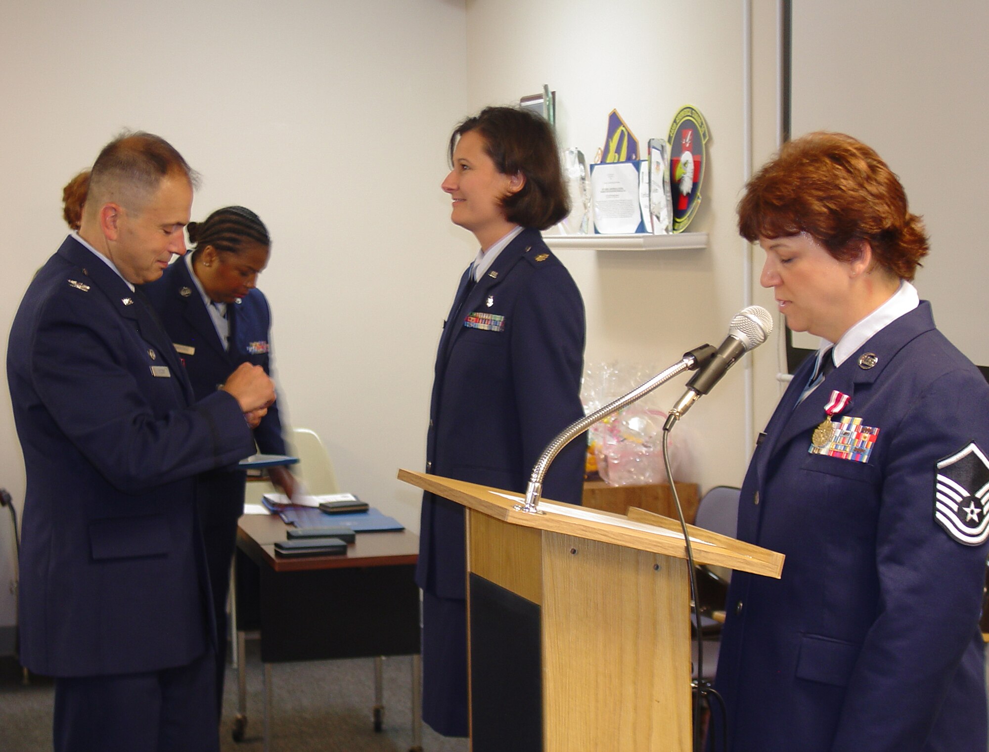 WRIGHT-PATTERSON AIR FORCE BASE, Ohio – Col. Oba Vincent, 445th Aeromedical Staging Squadron commander, pins the Meritorious Service Medal to the service coat of Maj. Rachel Sherwood during their unit's award ceremony Aug. 8 as Master Sgt. Melanie LaLiberty reads the order. (U.S. Air Force photo/Maj. Mary Reed)