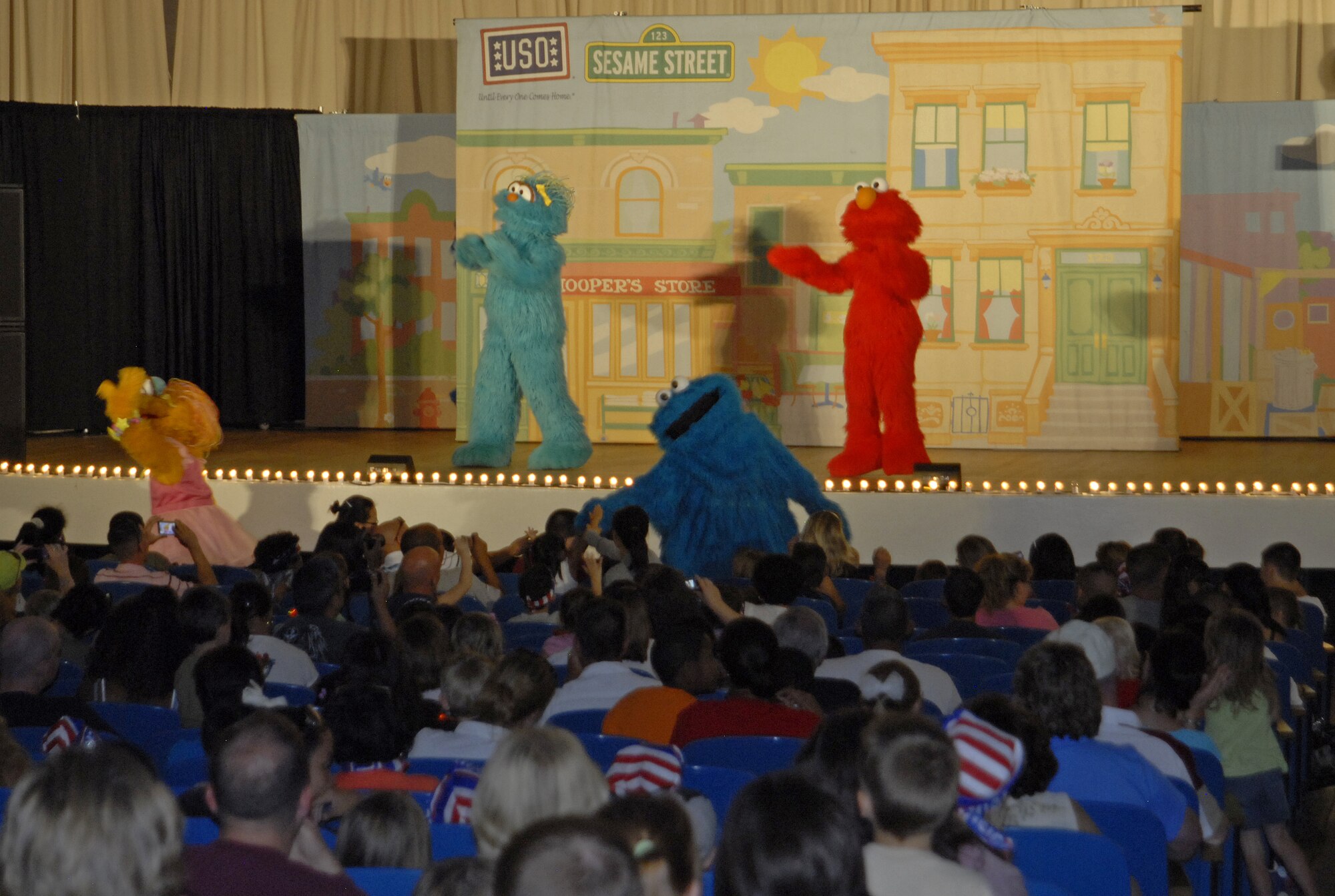 Cookie Monster greets audience members at the Sesame Street/USO Experience for Military Families performance, which took place at the Peterson Air Force Base auditorium July 31.  The Sesame Street initiatives help children and families develop critical skills, acquire healthy habits and build emotional strength to prepare them for lifelong learning. (U.S. Air Force Photo/Airman 1st class Jessica Hines)