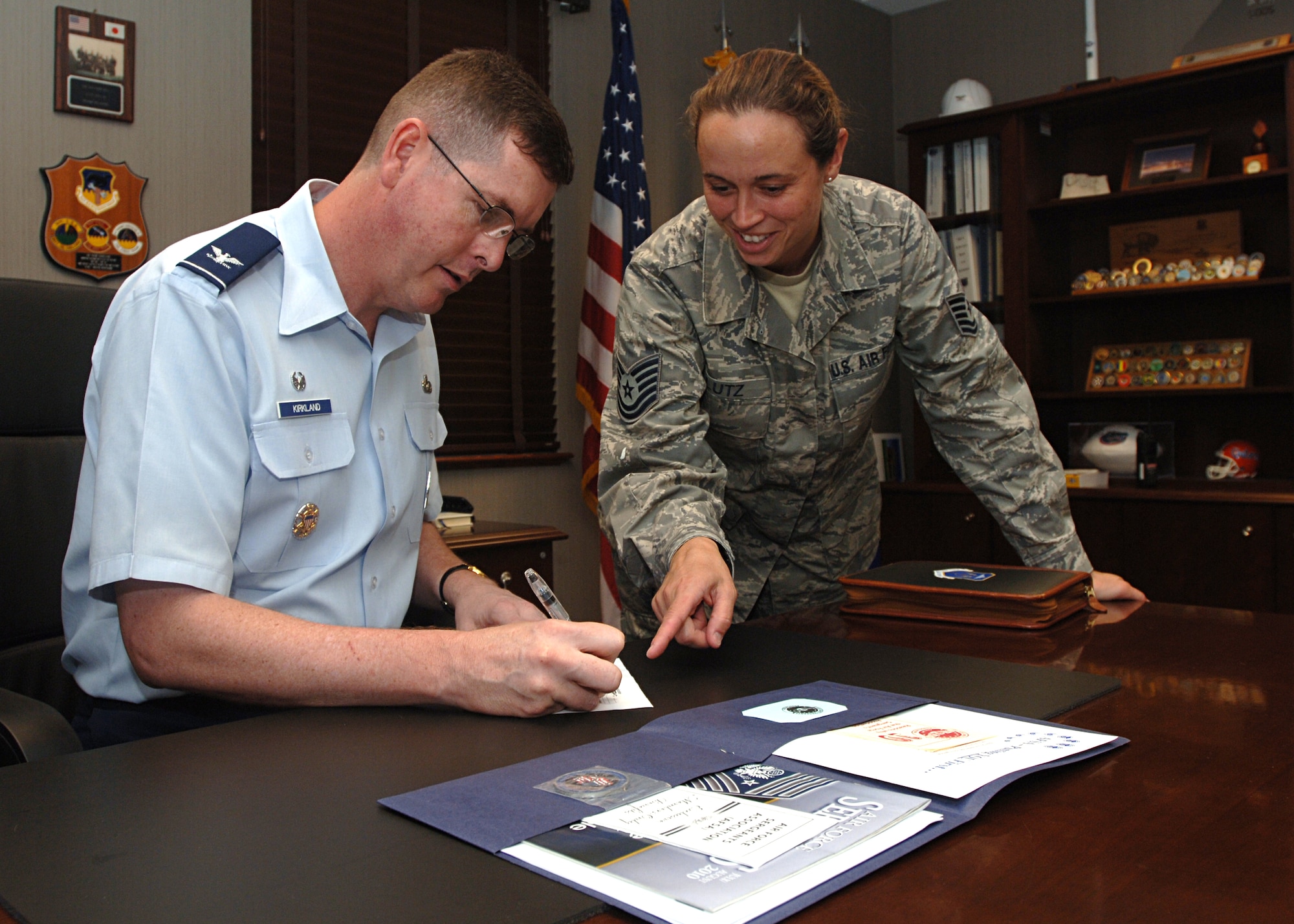 LANGLEY AFB, VA.--Col. Donald Kirkland, 633d Air Base Wing commander, signs the Air Force Sergeants’ Association membership form with the help of Tech. Sgt. Beverly Lutz, president of AFSA Chapter 358. The AFSA is a federally chartered, non-profit organization representing the professional and personal interests of active duty and retired enlisted members of the Air Force.  Colonel Kirkland said he was honored to be asked to be part of the organization.