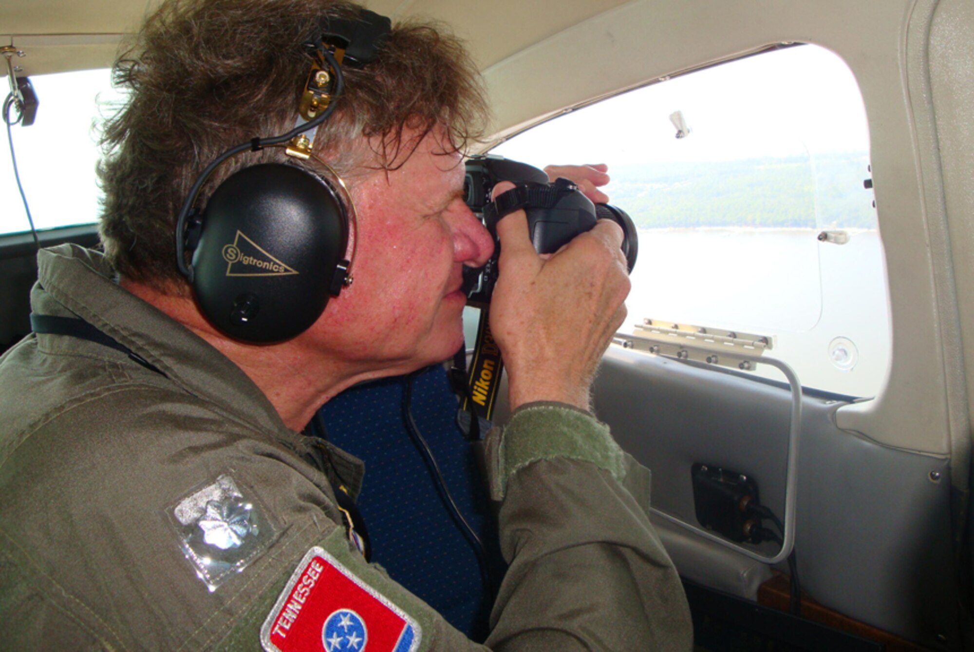 Charlie Smith, an ATA senior engineer and mission pilot for the Civil Air Patrol, lines up a photo out of the rear-seat swing window during an oil spill surveillance mission. (Photo provided)
