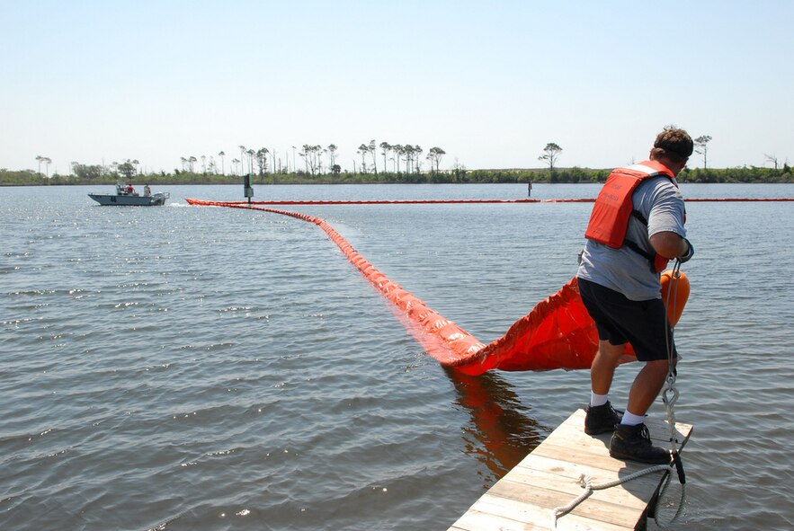 NAS PENSACOLA, Fla. (May 4, 2010) Naval Air Station Pensacola Pollution Response unit deploys oil containment boom at Sherman Cove aboard the base to protect environmentally sensitive grass beds from the Deepwater Horizon oil spill. Deepwater Horizon was an ultra-deepwater oil rig that sank April 22, causing a massive oil spill threatening the U.S. Gulf Coast. (U.S. Navy photo by Patrick Nichols/Released)