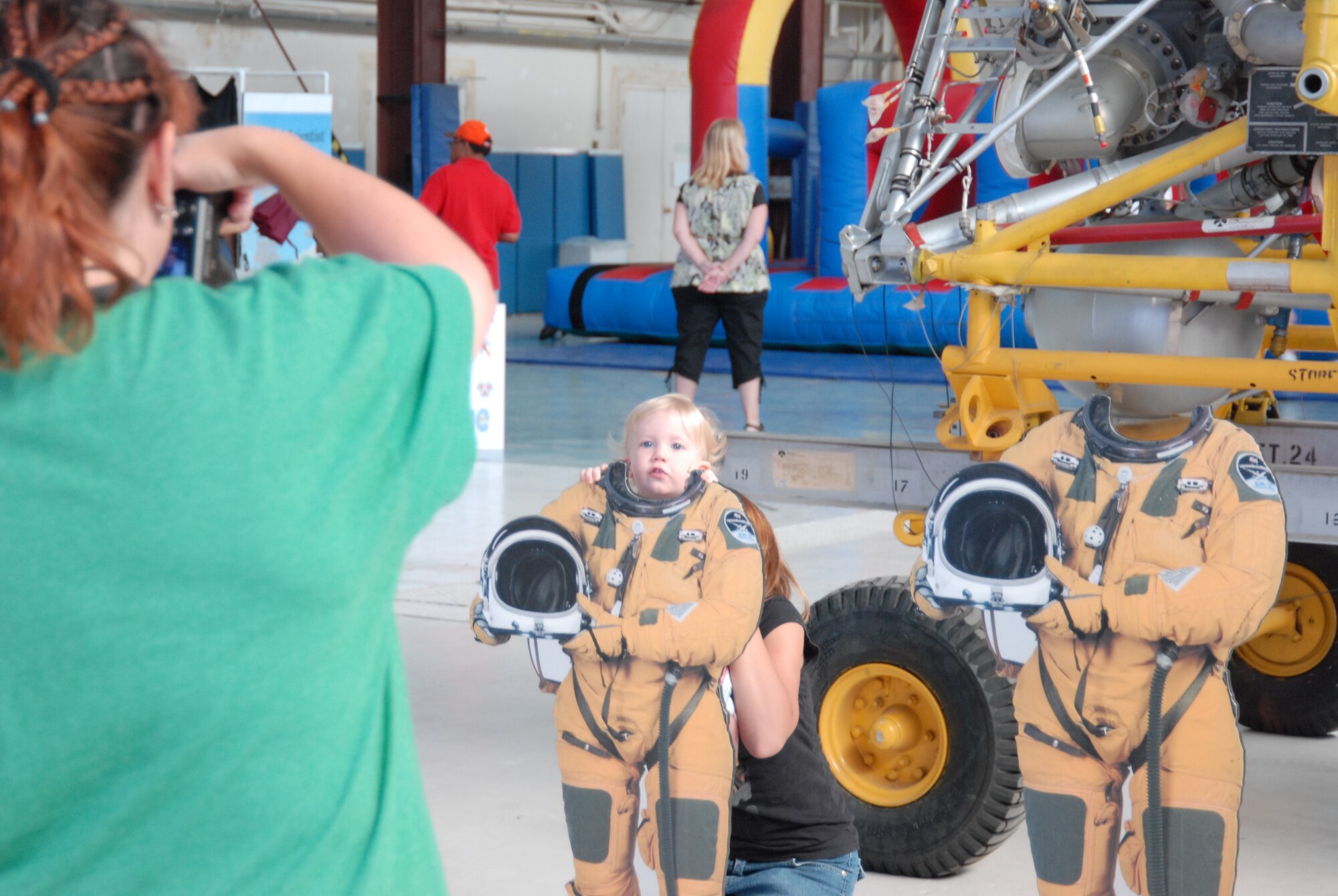 Children and family members pose as astronauts in front of rocket engines during the Air Force Research Laboratory's family day Aug. 5. (Air Force photo by Kenji Thuloweit)