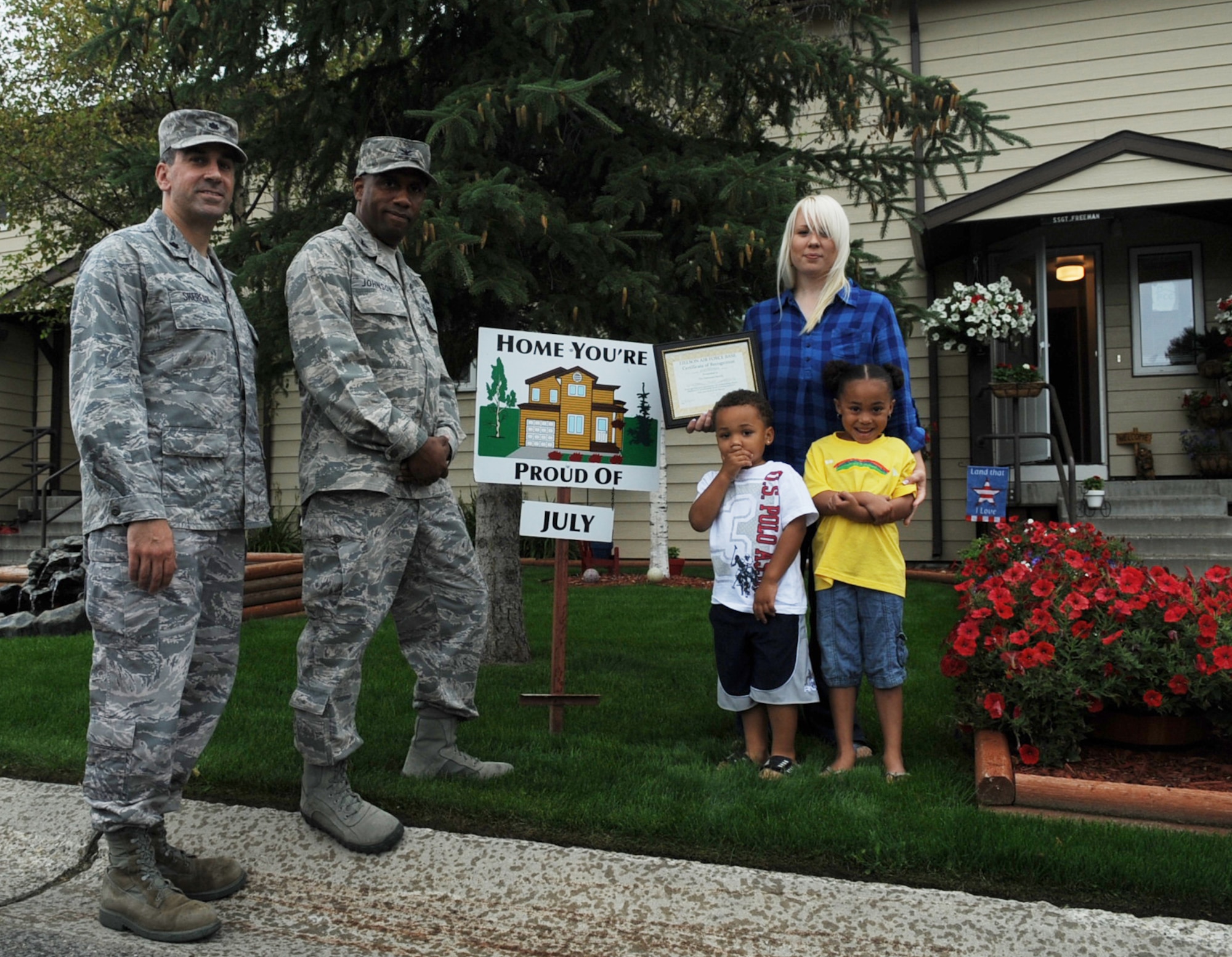 Chante Freeman and family display their "Home You're Proud Of " award with 354th Civil Engineer Squadron commander Lt. Col. Michael Sheredy and 354th Mission Support Group commander Col. Karlton D. Johnson, August 5, Eielson Air Force Base, Alaska. Each winning household recieves gift cards from various units on base and buisnesses off base. Not pictured is Staff Sgt. Ashley Freeman who is assigned to the 354th Aircraft Maintenance Squadron and is currently on temporary duty. (U.S. Air Force photo/Airman 1st Class Laura Goodgame)