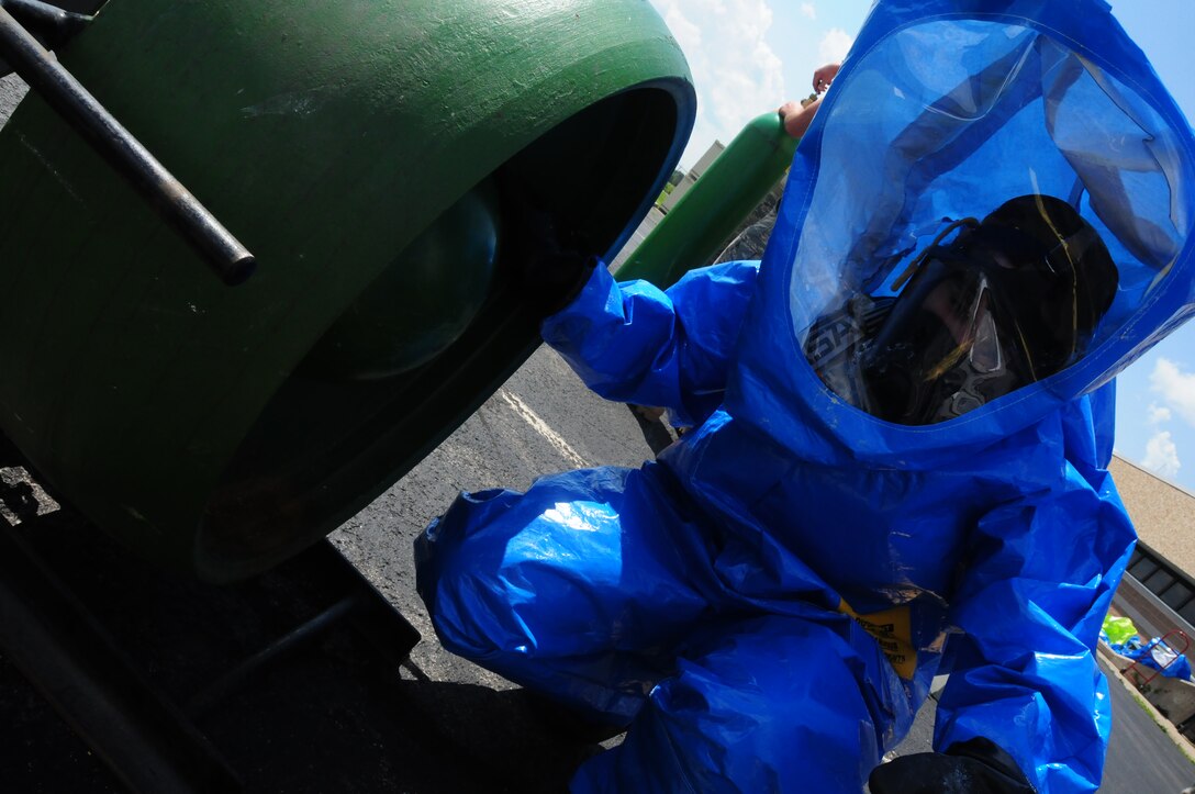 Senior Airman Michelle Schmitt, an Emergency Management Journeyman of the 107th Airlift Wing fixes a simulated leak a one-ton cylinder tank in her level-A  ensemble.