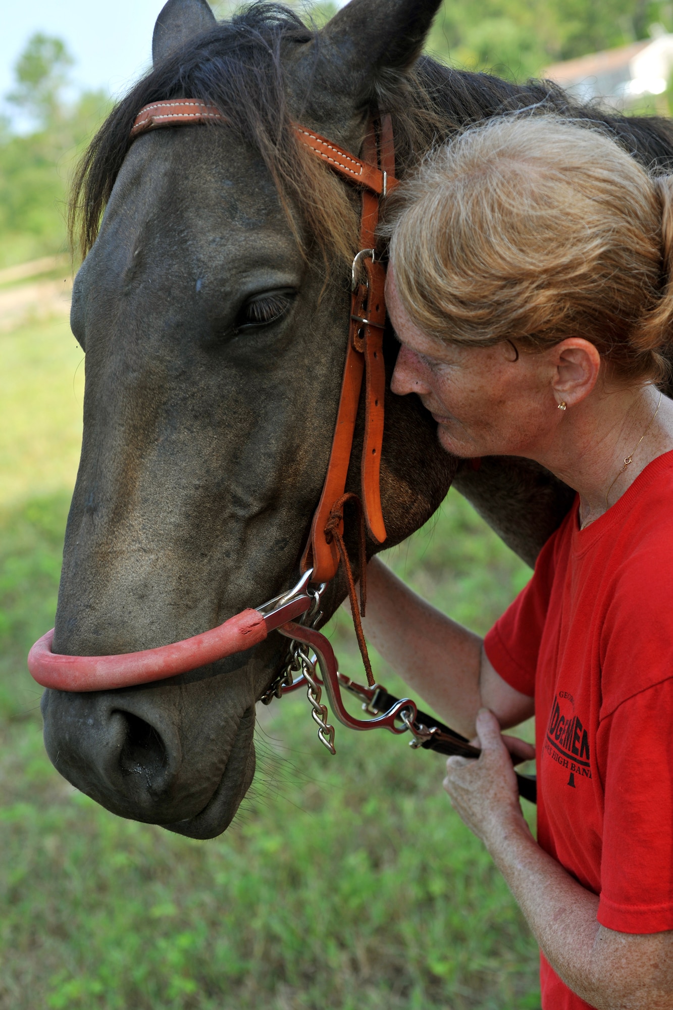 Maj. Laurie Abney pulls the face of Blue, a riding horse, into hers during a moment of relaxation at the Hopes and Dreams Riding Facility July 31, 2010, in Quitman, Ga. The Hopes and Dreams Riding Facility is a therapeutic horseback riding program and is an activity which has been proven to help relieve symptoms of brain trauma and stress-related disorders in many people, including combat veterans. Major Abney is the 23rd Medical Group education and training flight commander. (U.S. Air Force photo/Airman 1st Class Joshua Green)
