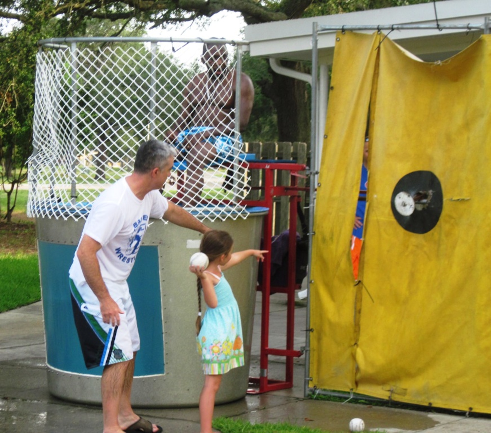 Chief Master Sgt. Jackie Green, 325th Fighter Wing command chief, assists at the dunk tank during the National Night Out block party Aug. 3 on Tyndall. The 27th Annual National Night Out is a unique crime and drug prevention event organized for Tyndall by Samantha Hilton, resident specialist and Lifeworks coordinator for Balfour Beatty Communities. The event secured sponsors and participation from all of the base members, Balfour Beatty Communities team, and local authorities who came out and donated all of the games, activities, safety demonstrations and food. (Photo by Samantha Hilton)