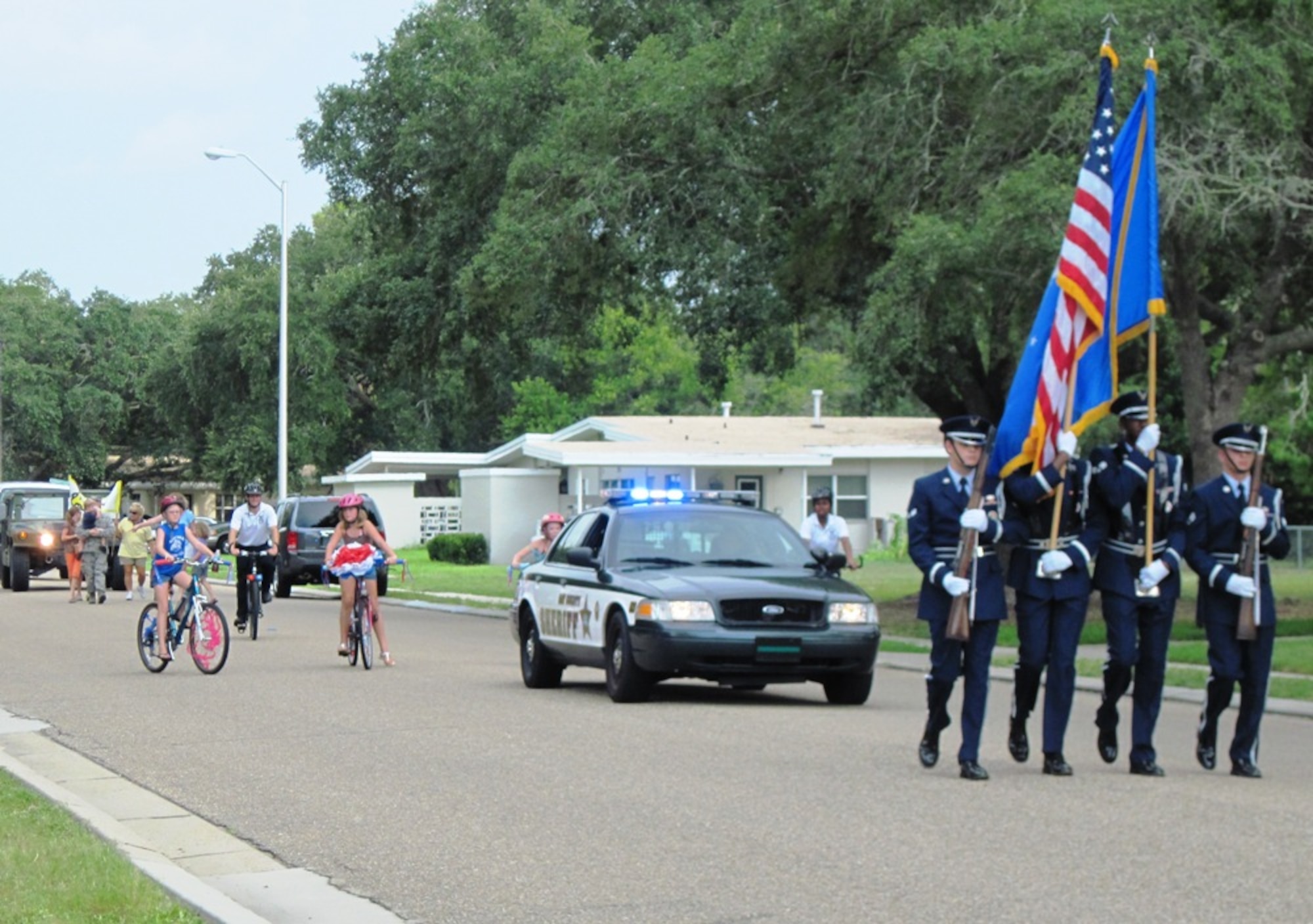 Tyndall honor guard members Senior Airman Brandon Overstreet-Vinnett, Senior Airman Eric Parker, Airman 1st Class Chase Skinner, and Airman 1st Class Vernal Burnette carry the colors in the parade during the National Night Out block party Aug. 3 on Tyndall. The 27th Annual National Night Out is a unique crime and drug prevention event organized for Tyndall by Samantha Hilton, resident specialist and Lifeworks coordinator for Balfour Beatty Communities. The event secured sponsors and participation from all of the base members, Balfour Beatty Communities team, and local authorities who came out and donated all of the games, activities, safety demonstrations and food. (Photo by Samantha Hilton)