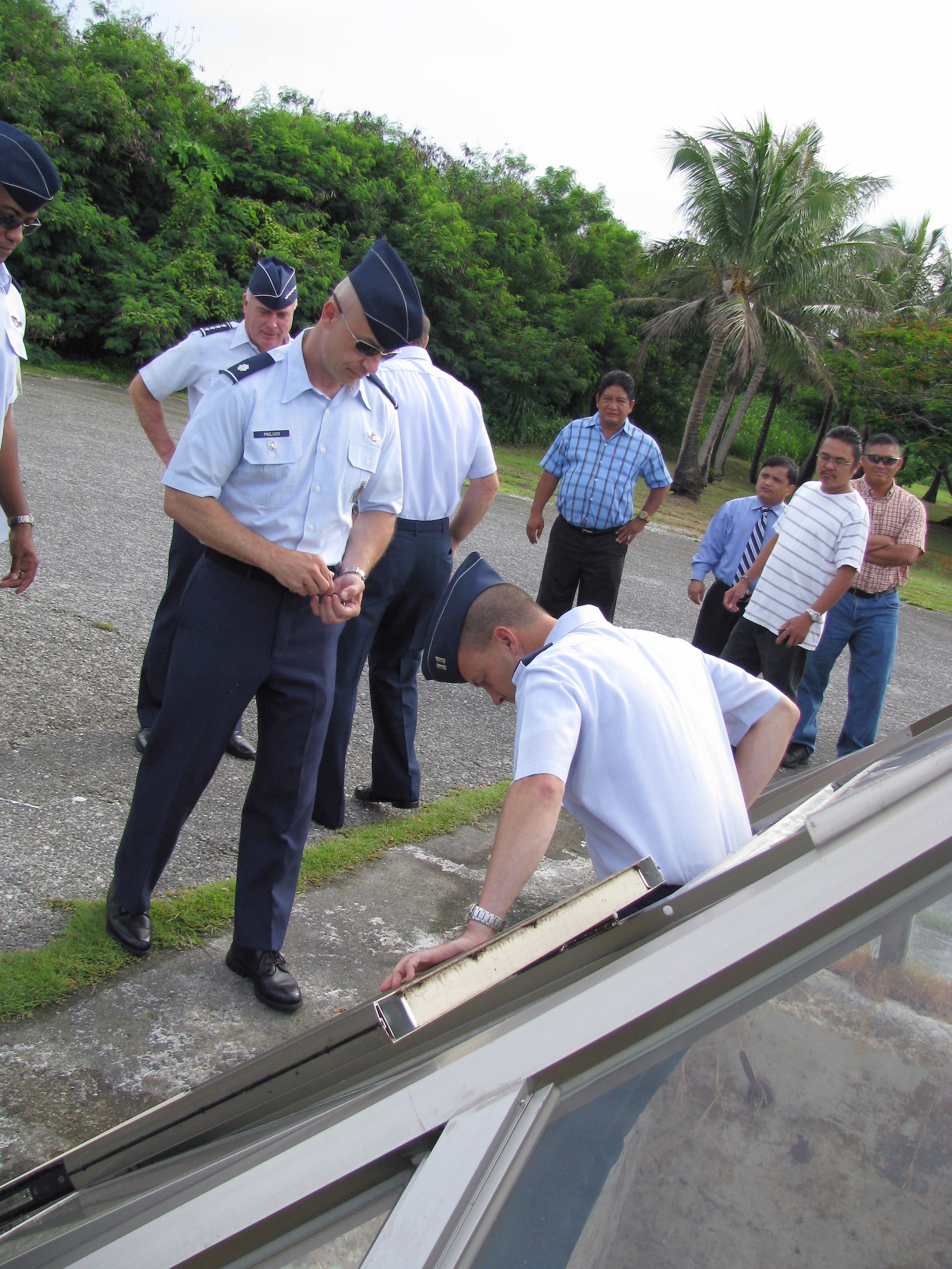 Capt. Ron Poe climbs into the pit used to load atomic bombs onto B-29 Superfortresses at the end of World War II, while Lt. Col. Richard Pagliuco prepares to follow him, shortly before a wreath-laying ceremony Aug. 6, 2010, in Tinian, Commonwealth of Northern Mariana Islands. Both were invited by local officials to place unit coins in the bomb pit during a commemoration of Tinian's role in World War II. Colonel Pagliuco is the 20th Air Force deputy director of operations at F.E. Warren Air Force Base, Wyo., and Captain Poe is the 509th Aircraft Maintenance Squadron Aircraft Maintenance Unit officer in charge at Whiteman AFB, Mo. (U.S. Air Force photo/Lt. Col. Sam Highley)