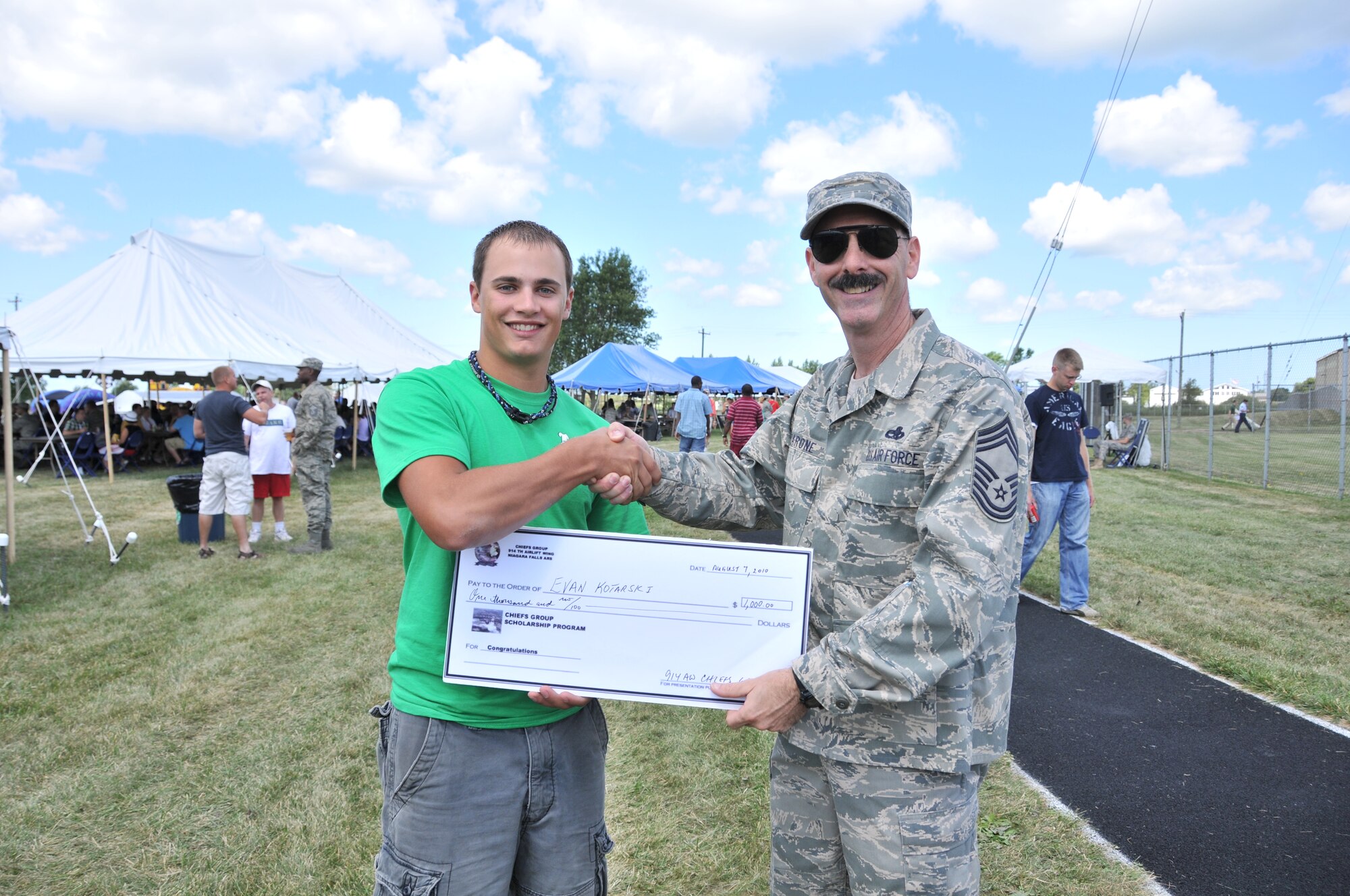 The Niagara Chief's Group and Air Force Sergeants Association scholarship winner Evan Kotarski  being given his big check by Chief Master Sgt. Francis Barone during the 914th Family Day event August 7, 2010, Niagara Falls Air Reserve Station, NY. Kotarski won his scholarship by writing a 500 word essay on the topic "How has Air Force humanitarian missions changed from the Berlin Airlift to today". (U.S. Air Force photo by Staff Sgt. Joseph McKee)
