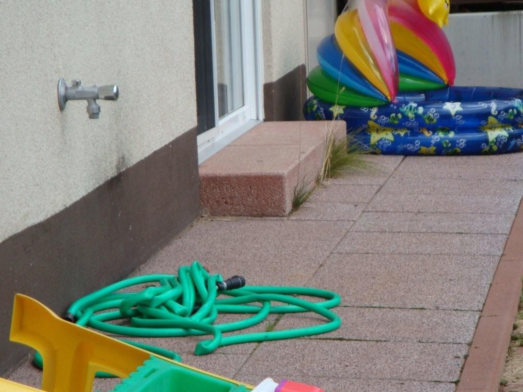 Toys and a waterhose sit outside in the yard of a base house in the Kaiserslautern Military Community housing area. Recently, during weekly exterior inspections, it has been noticed that some residents are not keeping their homes and yards up to standard. All toys are to be stored in neat fashion and hoses are to be rolled up neatly. (Courtesy photo)