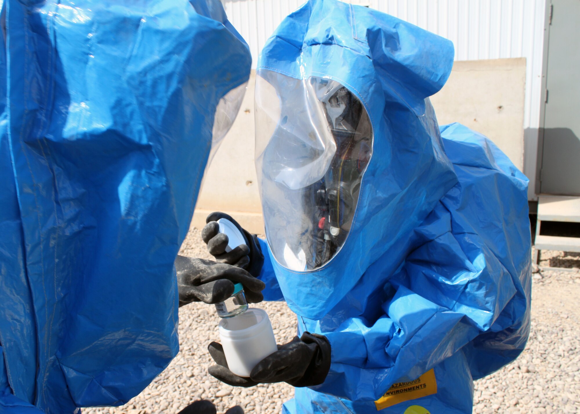 Senior Airmen Nathan Krajcirik (left) and Nadege James, 332nd Civil Engineer Squadron Emergency Management Section technicians, places a sample of an “unknown” powder into a protective container, which will be sealed by for transport to a lab for further tests, during training Aug. 3, 2010, Joint Base Balad, Iraq.  EM Airmen can test a variety of potential chemical, biological or nuclear hazards in any form.  Airman Krajcirik, a native of Lansford, Penn., is deployed from Langley Air Force Base, Va.; Airman James, a native of Pompano Beach, Fla., is deployed from Nellis Air Force Base, Nev.  (U.S. Air Force photo/Staff Sgt. Stacy Fowler)