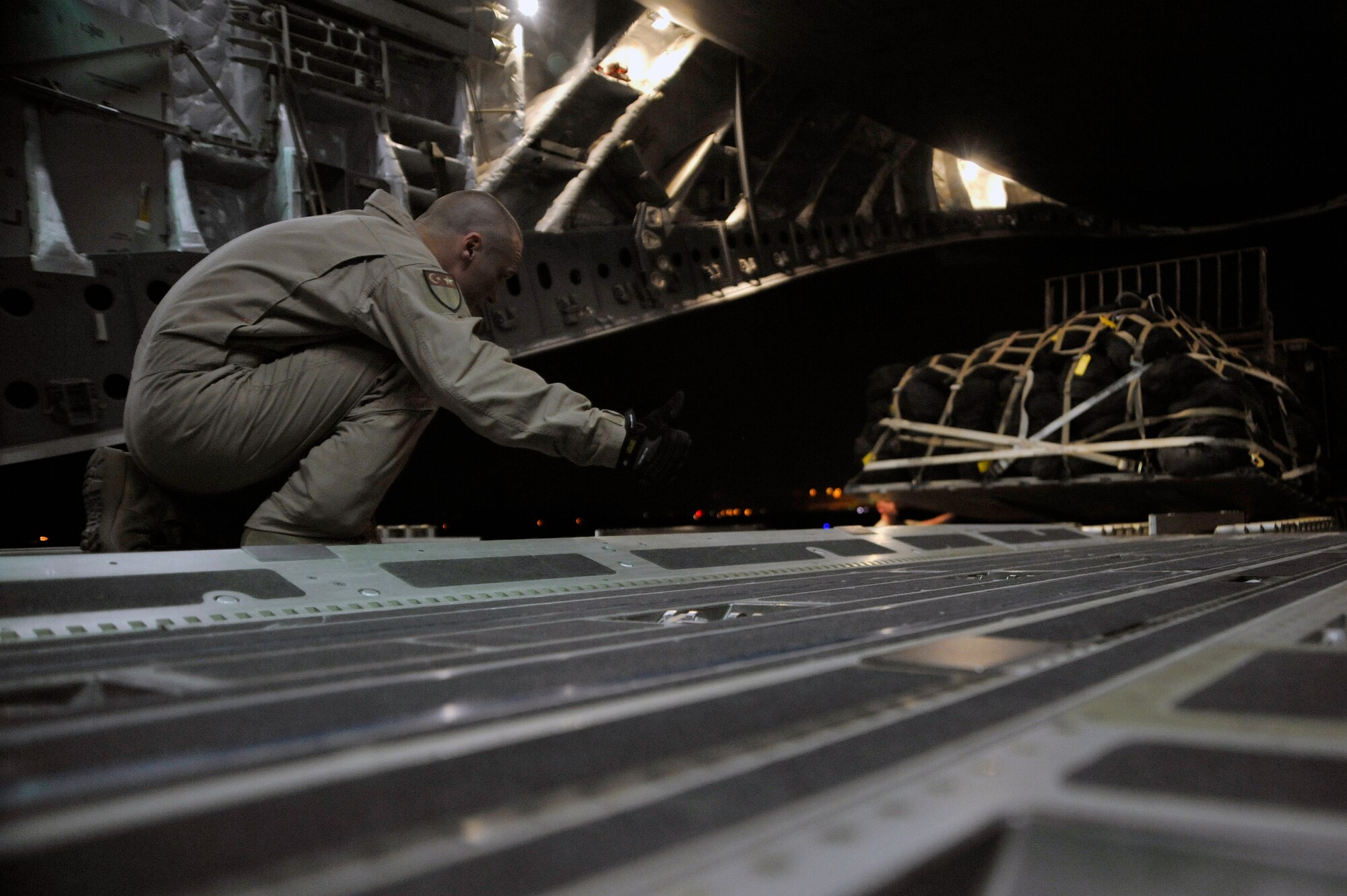 A C-17 Globemaster III loadmaster gives the thumbs up to 447th Expeditionary Logistics Readiness Squadron aerial porters while loading palletized baggage, Aug. 6, 2010, at Sather Air Base, Iraq. Air Force assets have been able to continue normal personnel and cargo movements along with supporting the Responsible Drawdown of Forces, which is on track to bring the number of operational forces down to 50,000 troops. ( U.S. Air Force photo by Senior Airman Perry Aston) (Released)
