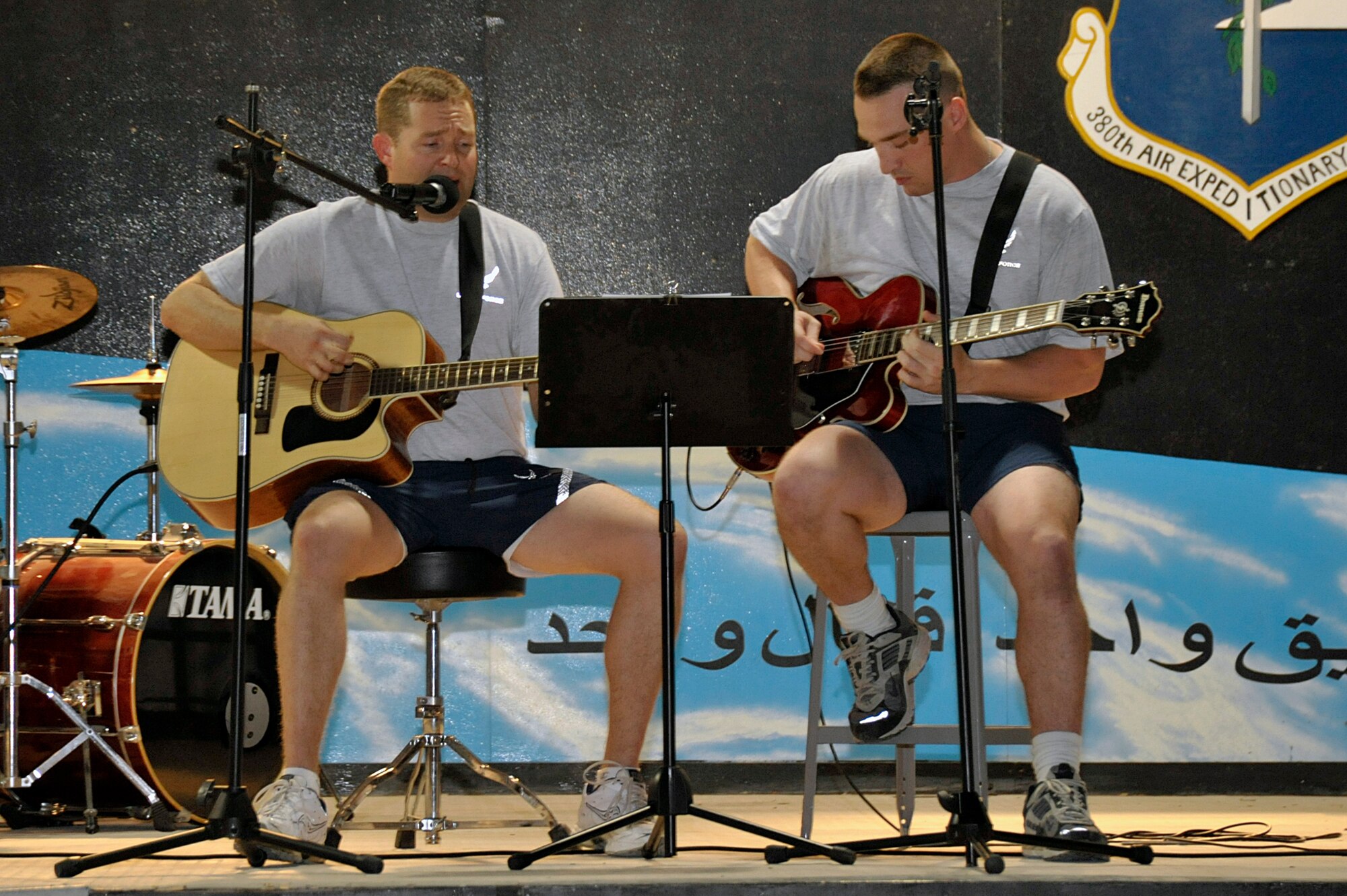 Maj. Richard Dawson (left), 380th Expeditionary Contracting Squadron, and Tech Sgt. Sean Blumenhein, 380th Expeditionary Communications Squadron, perform a song written by Major Dawson during Open Mic Night Aug. 6 at an undisclosed location in Southwest Asia. Airmen and Soldiers participated in the event by singing, playing musical instruments, rapping, dancing and performing comedy routines. (U.S. Air Force photo/Tech. Sgt. April Wickes)