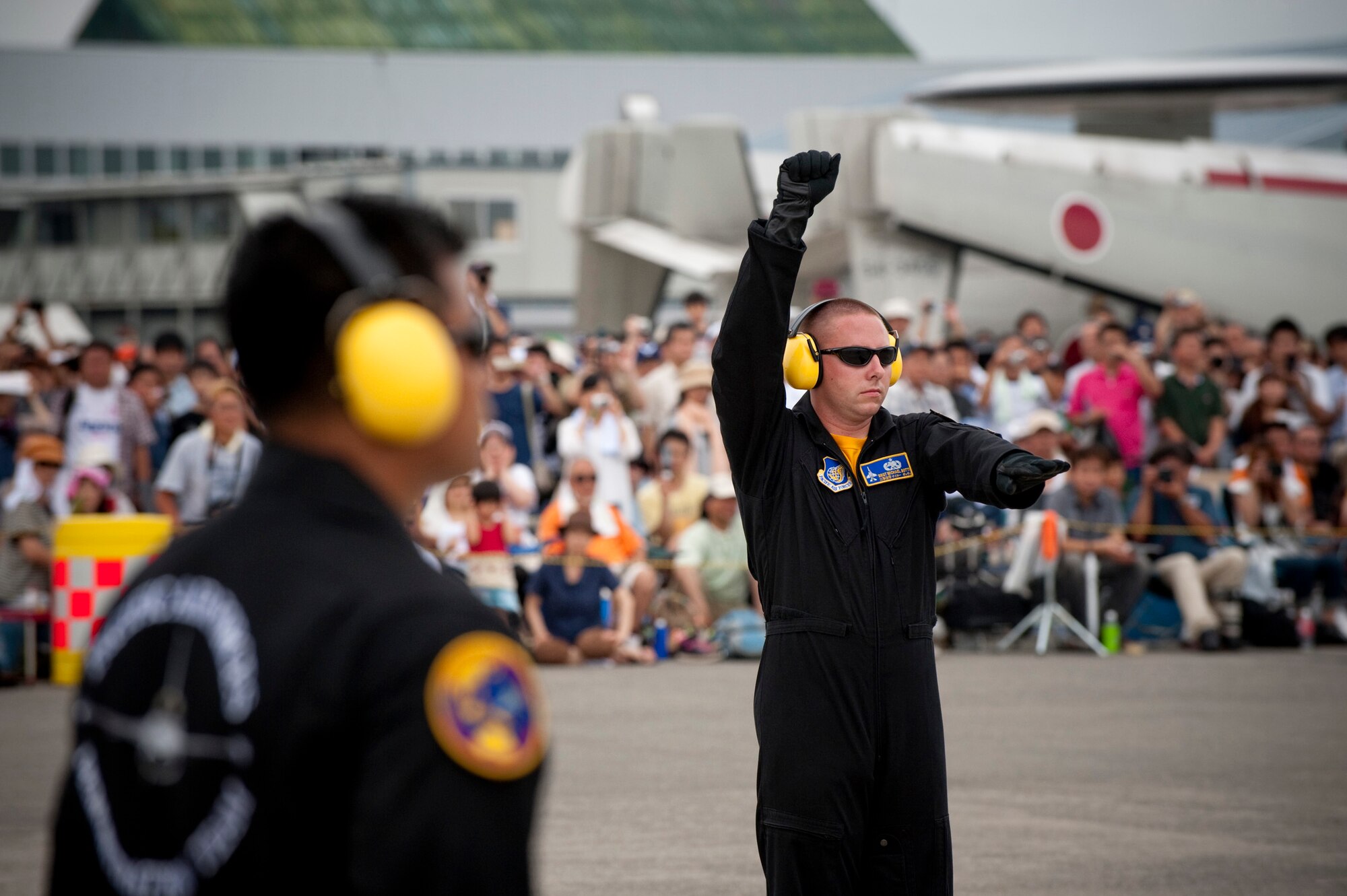 CHITOSE AIR BASE, Japan -- Staff Sgt. Michael Botti, Pacific Air Forces Demonstration Team crewchief, signals to relay information to the Capt. Jeffrey Schneider, PACAF Demo Team pilot, during preflight checks at the Chitose Air Festival, Aug. 8. For demonstrations, hand signals replace the more common use of two-way audio headsets. (U.S. Air Force photo/Staff Sgt. Samuel Morse)
