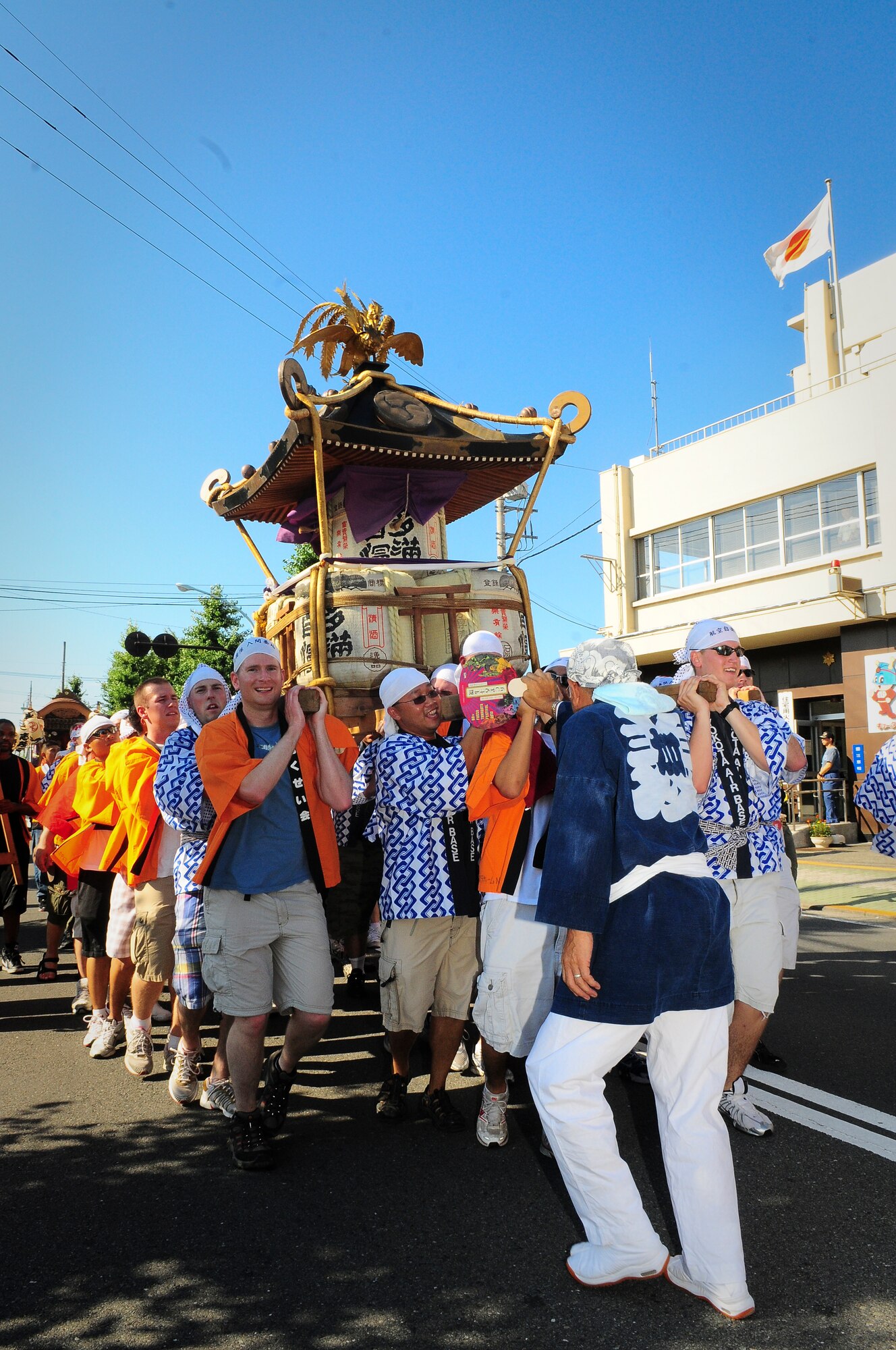 YOKOTA AIR BASE, Japan -- Military members from Yokota Air Base, Japan, sing and carry a Mikoshi (shrine) during the Fussa Tanabata Festival Aug. 6. The festival itself featured a number of different groups carrying Mikoshi (shrines) and mobile stages featuring performances of traditional Japanese characters such as a fox and an Oni, or a demon. At many points during the march the groups would raise the shrines and cheer in front of the stages. The festival included performances of traditional Japanese dancing and the carrying of Shrines from Shinmeisya Shrine to Fussa City Hall. (U.S. Air Force photo/Staff Sgt. Stacy Moless)
