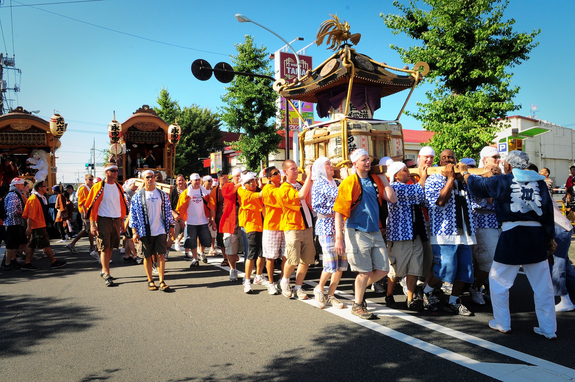 YOKOTA AIR BASE, Japan -- Military members from Yokota Air Base, Japan, sing and carry a Mikoshi (shrine) during the Fussa Tanabata Festival Aug. 6. The festival itself featured a number of different groups carrying Mikoshi (shrines) and mobile stages featuring performances of traditional Japanese characters such as a fox and an Oni, or a demon. At many points during the march the groups would raise the shrines and cheer in front of the stages. The festival included performances of traditional Japanese dancing and the carrying of shrines from Shinmeisya Shrine to Fussa City Hall (U.S. Air Force photo/Staff Sgt. Stacy Moless)
