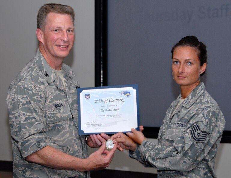 KUNSAN AIR BASE, Republic of Korea -- Col. John Dolan, 8th Fighter Wing commander, presents Tech. Sgt. Rachel Staub, 8th Fighter Wing NCO in charge of military justice, with a Pride of the Pack award Aug. 5. (U.S. Air Force photo/Staff Sgt. Amanda Savannah)