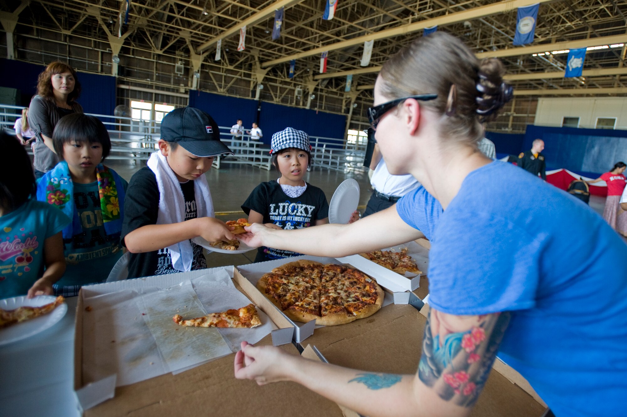 MISAWA AIR BASE, Japan -- Senior Airman Arin Vickers, 35th Aircraft Maintenance Squadron maintenance supply liaison, serves pizza to children from the Hirosaki Aiseien orphanage during Friendship Day Aug. 5 at Hangar 949. The pizza was donated by the Misawa Officer's Spouses Club. The children partook in the pizza before viewing a show by the Pacific Air Forces F-16 Demonstration Team. (U.S. Air Force photo/Senior Airman Jamal D. Sutter)
