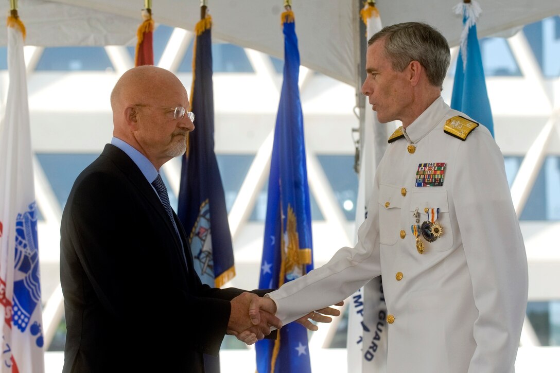 James R. Clapper Jr., left, the Director of National Intelligence, presents an award to Navy Vice Adm. Robert B. Murrett, outgoing director of the National Geospatial-Intelligence Agency, during a ceremony to mark the changing of directors at the agency's new east campus in Springfield, Va., Aug. 9, 2010.