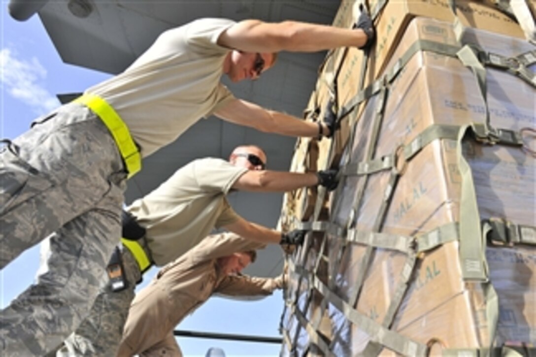 U.S. Air Force airmen from the 455th Air Expeditionary Wing push pallets of halal meals onto a C-130H Hercules aircraft at Bagram Airfield, Afghanistan, on Aug. 1, 2010.  The meals were delivered to Pakistan as part of a humanitarian relief mission in the wake of monsoon floods caused by torrential rains devastating hundreds of thousands in the country.  