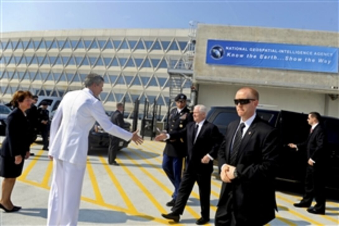 Defense Secretary Robert M. Gates shakes hands with Navy Vice Adm. Robert B. Murrett, outgoing director of the National Geospatial-Intelligence Agency, and Letitia Long, incoming director, upon his arrival at the agency's new east campus in Springfield, Va., Aug. 9, 2010. Murrett relinquished command to Long, who is the first female to head a U.S. intelligence agency.